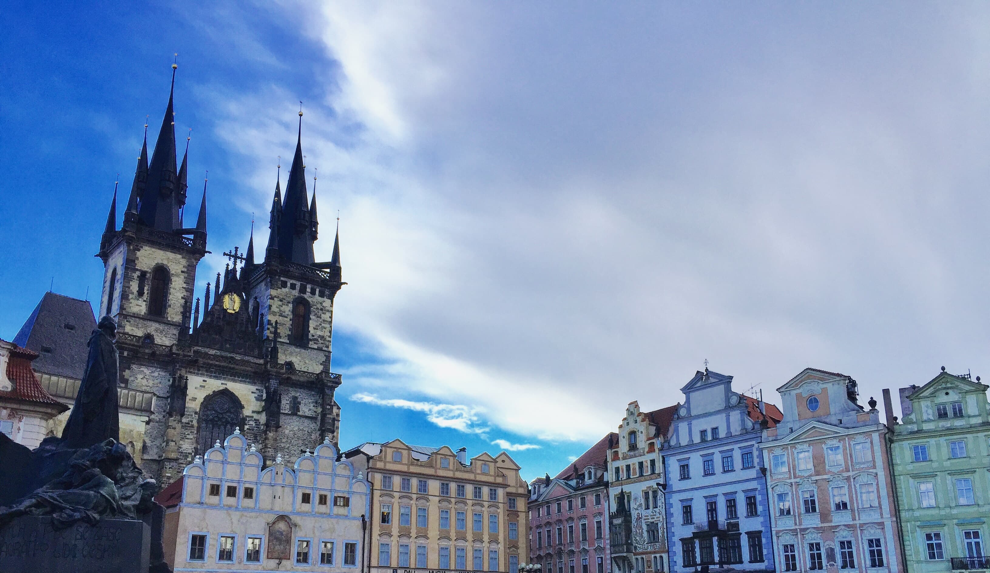 View of a beautiful town square lined with colorful buildings and a church with two spires