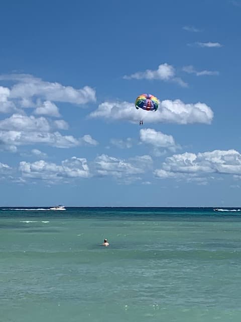 View of a parasail high above the ocean on a sunny day