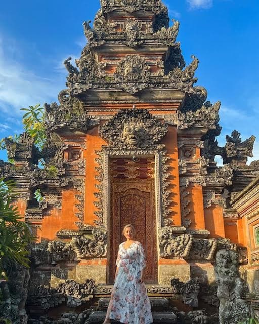 Advisor in a dress in front of an orange temple on a sunny day