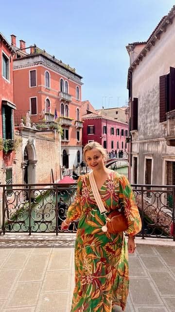 Advisor in a colorful dress on a bridge in Venice on a sunny day