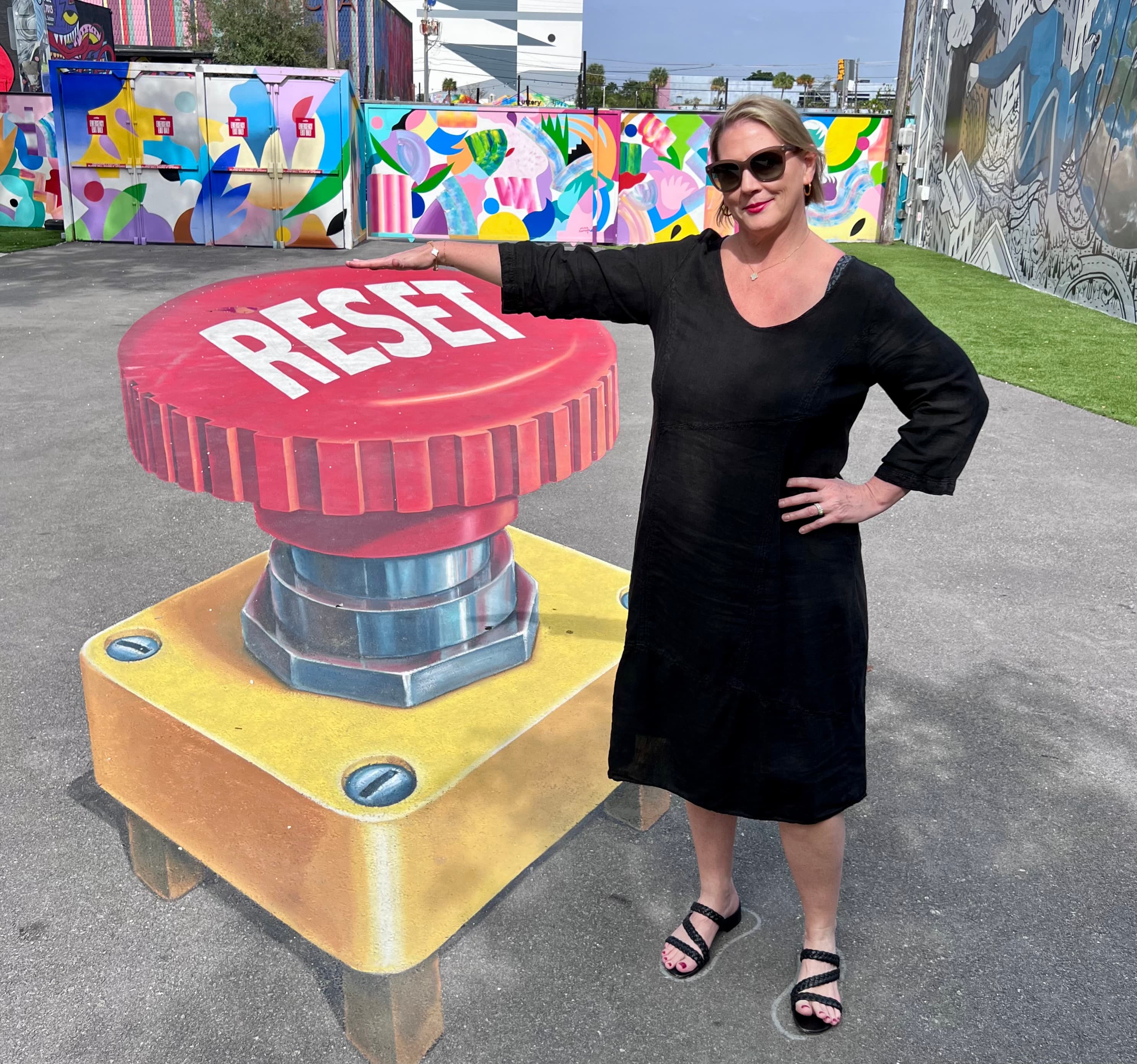Advisor pausing next to a sculpture of a giant "Reset button."