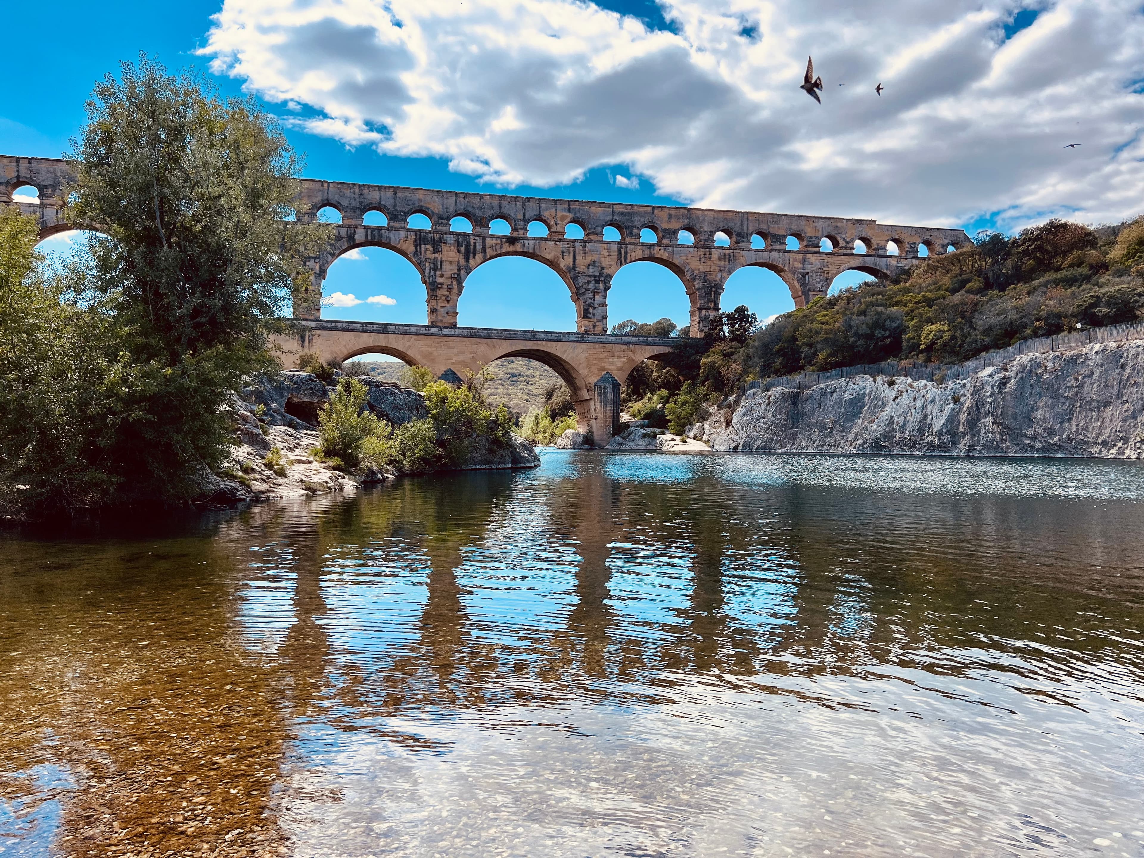 A large highway bridge crosses a river, photographed from below.