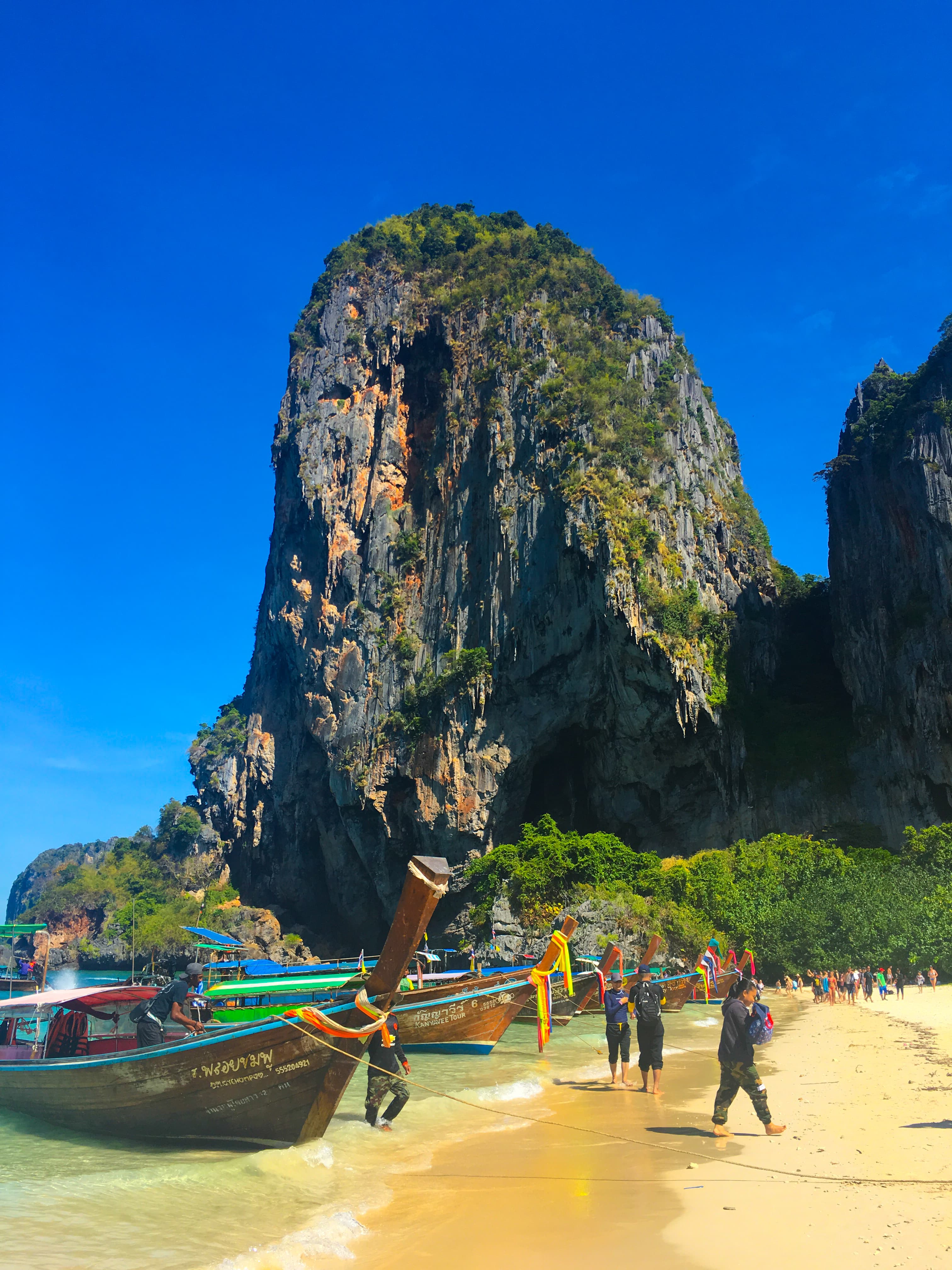 View of a beach with colorful boats on shore under sunny skies