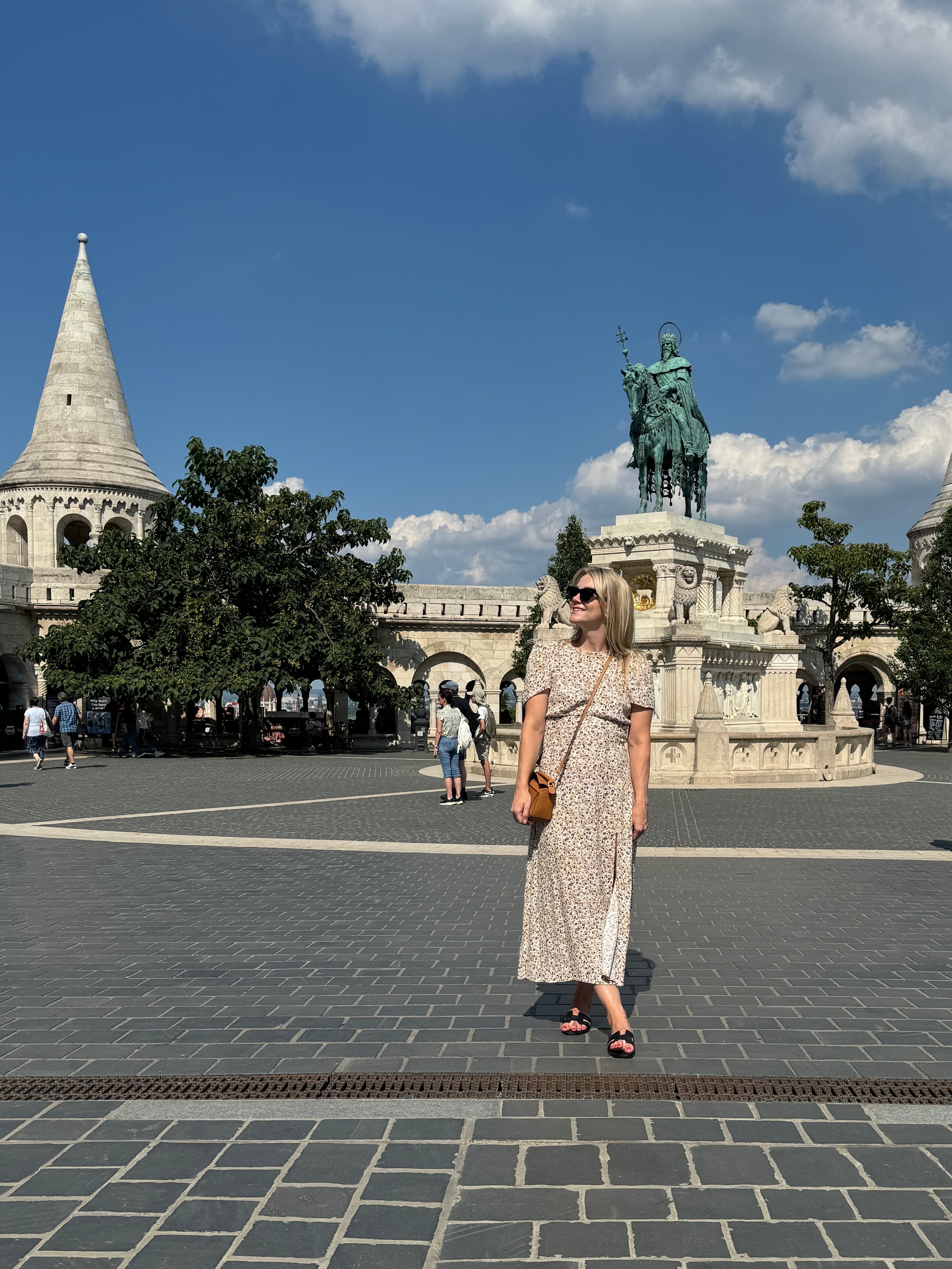 Advisor in a long dress standing in a plaza on a sunny day