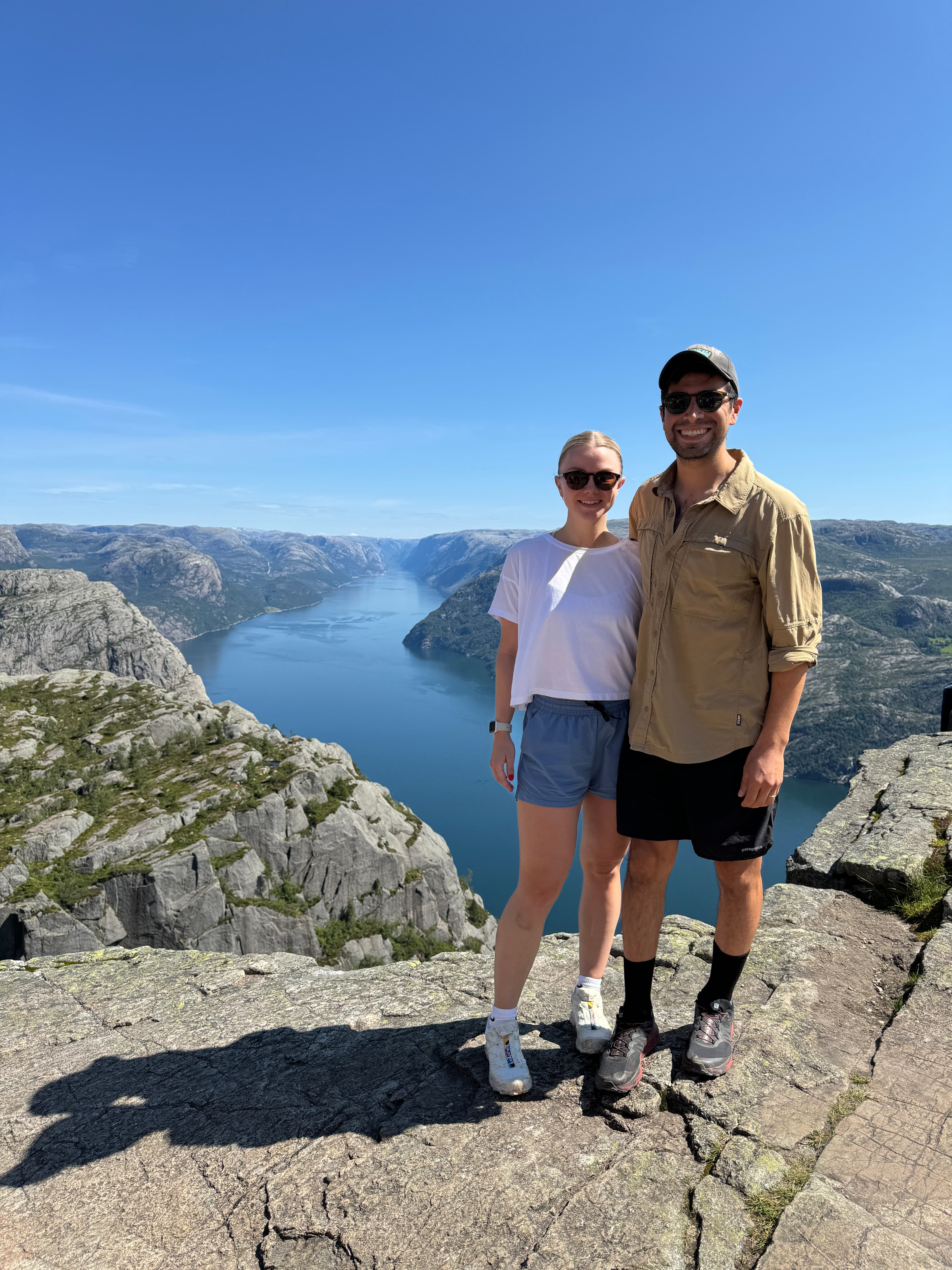 Advisor and partner side by side at a viewpoint overlooking a beautiful river canyon under clear skies