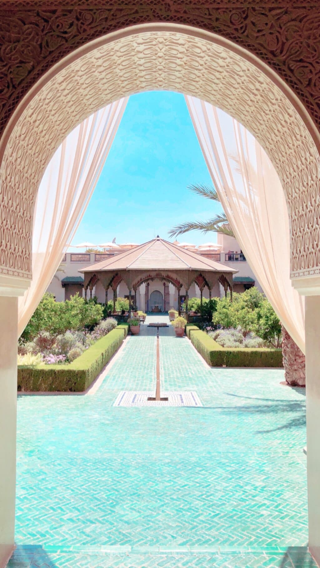 View of a pretty resort pool seen through an archway