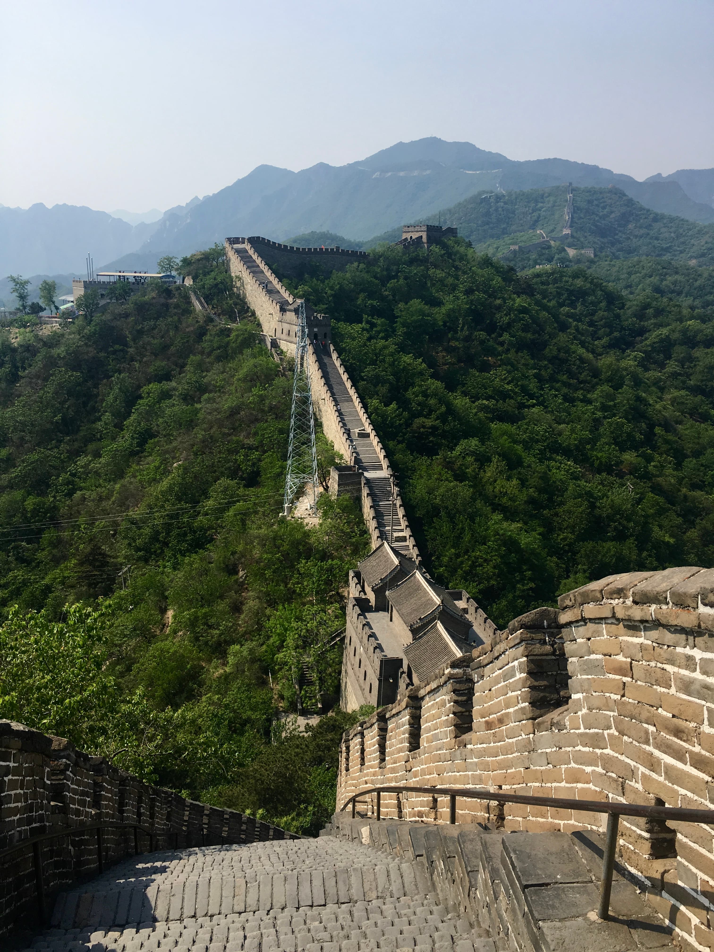 View of the Great Wall of China stretching over lush green mountains