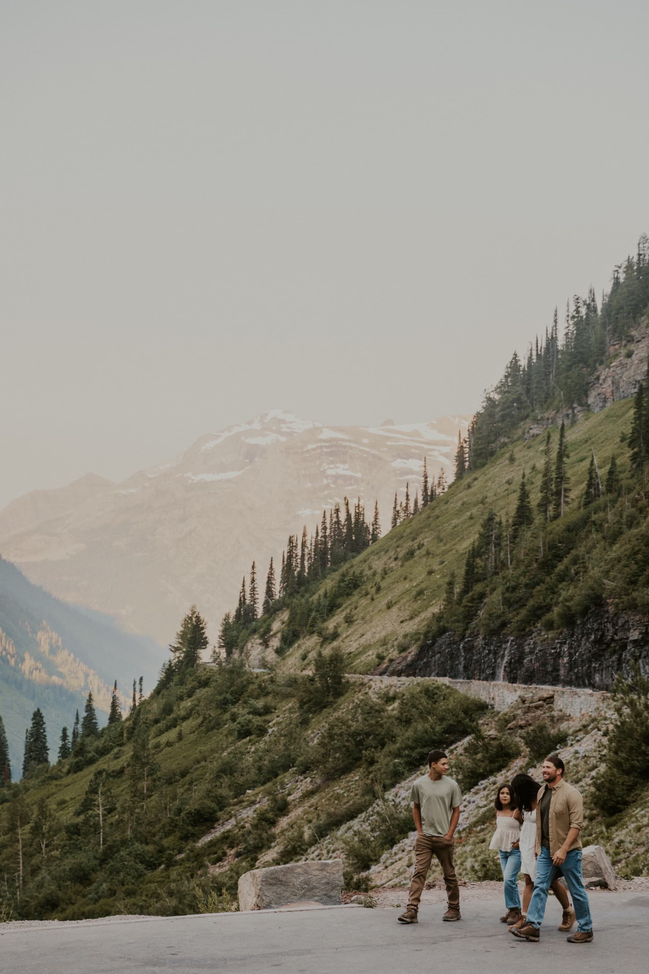 View of several people on a hike through a green mountain landscape