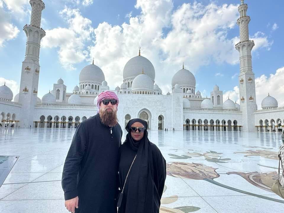 Advisor and partner posing side by side at a large white marble mosque