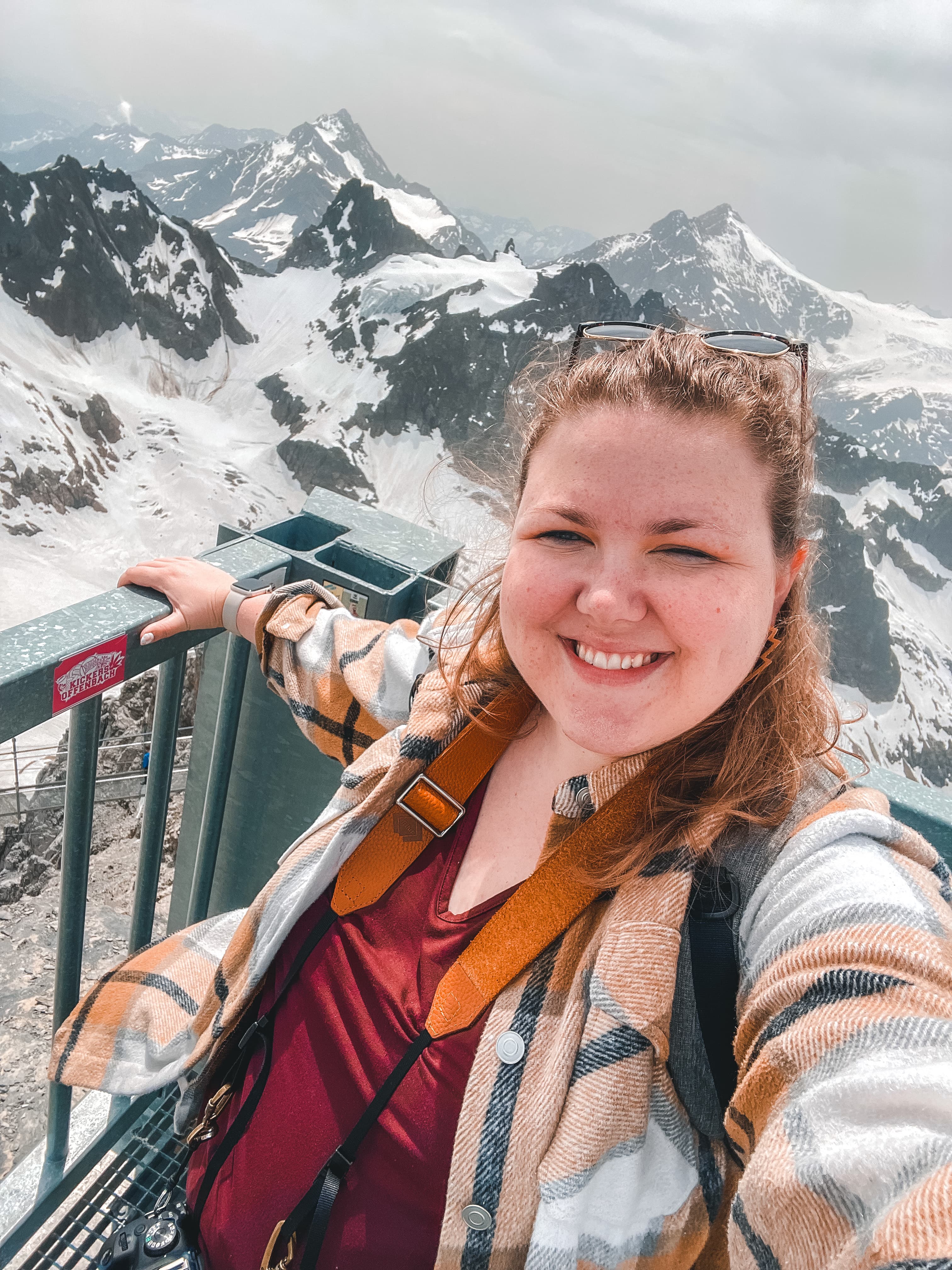 Advisor taking a selfie on a balcony overlooking a beautiful snowy mountain range