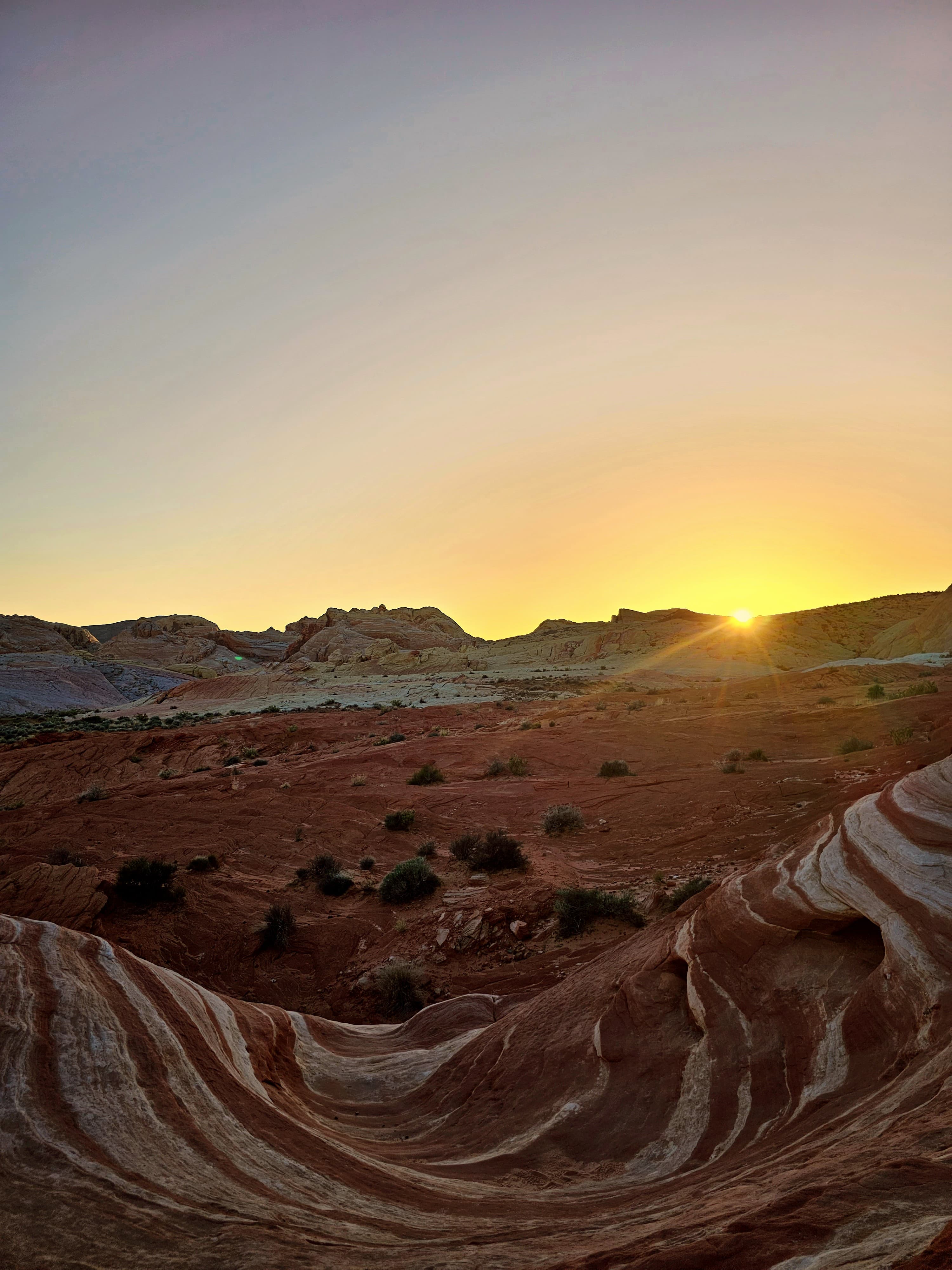 A picture of the sun rising over the grand canyon and open desert lands.