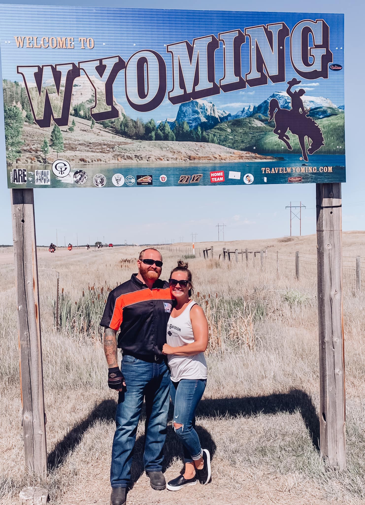 Advisor posing front of a sign that reads "Wyoming" during the day.