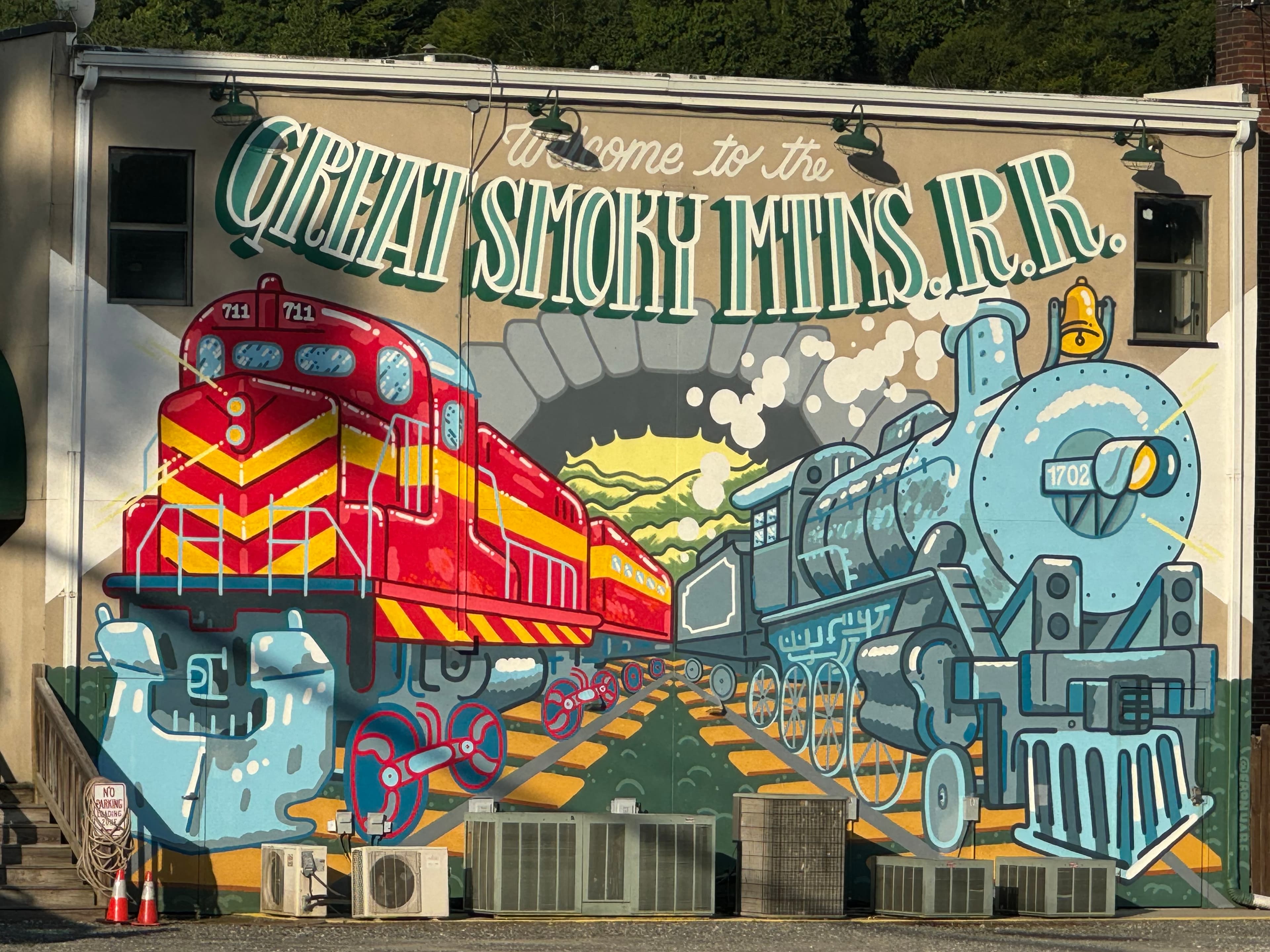 A mural with two trains on it welcoming guests to the great smoky mountains.