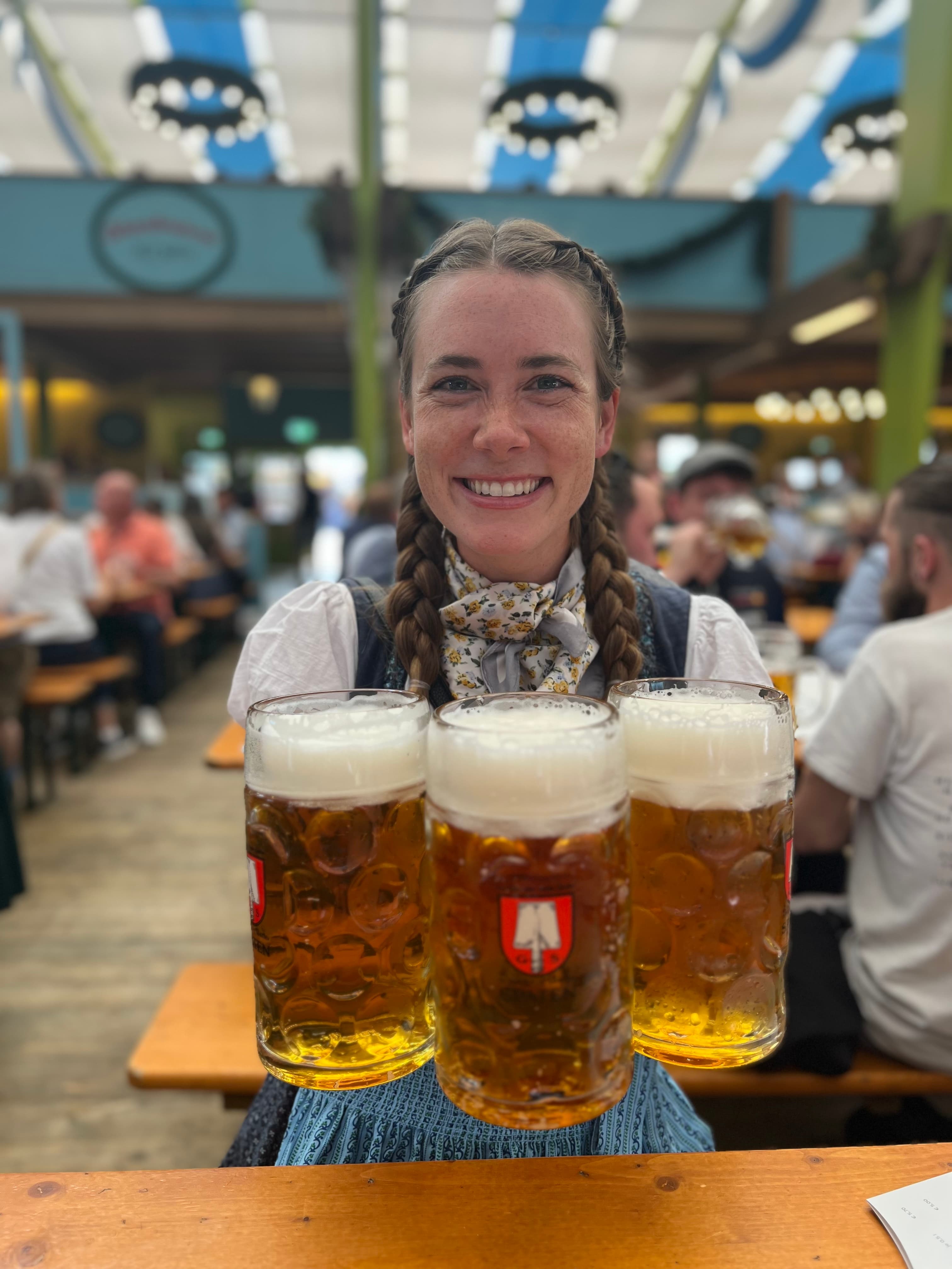 Advisor holding three full liter steins of beer at Oktoberfest