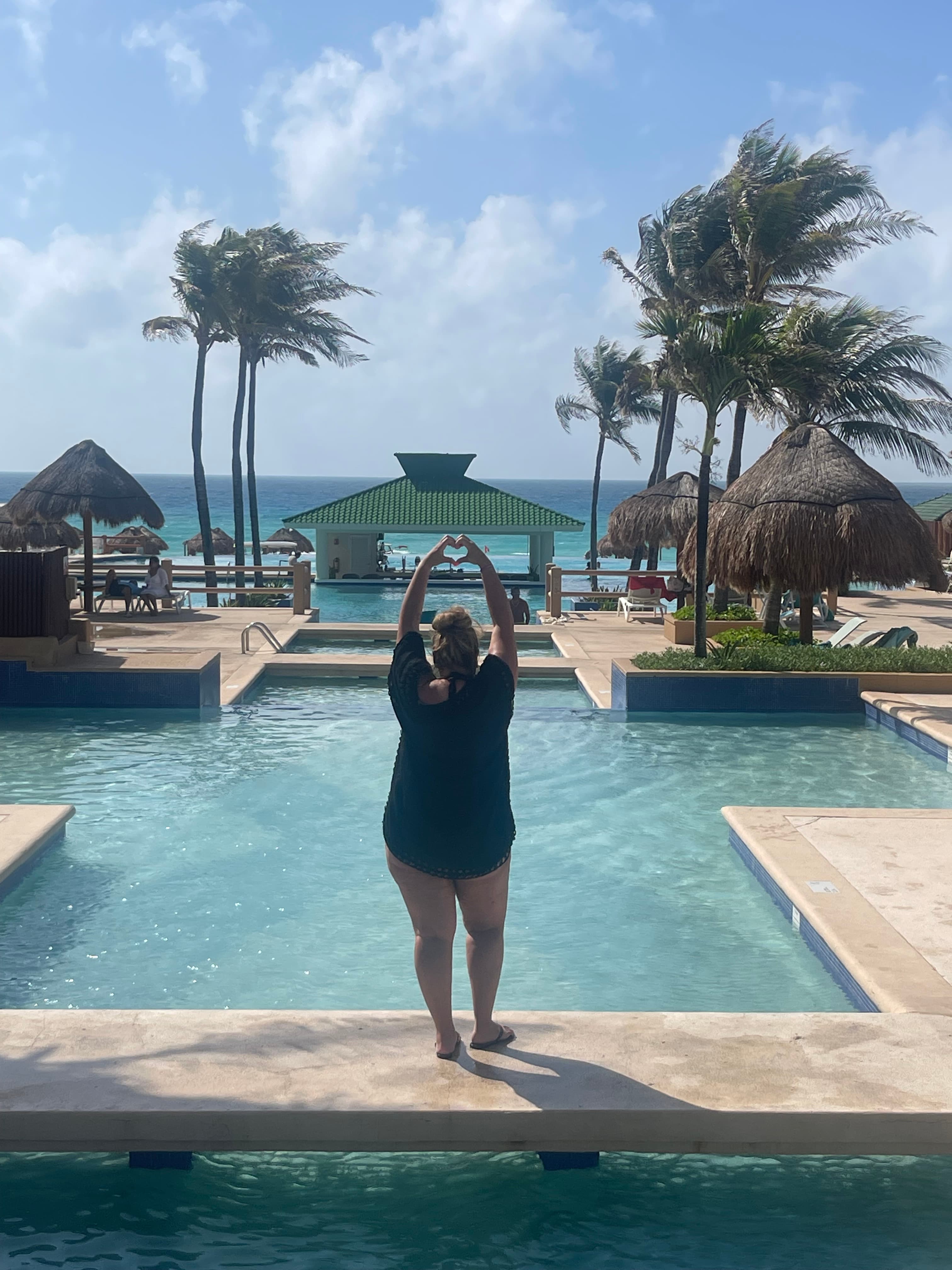 Cammy posing in front of a pool during the daytime.