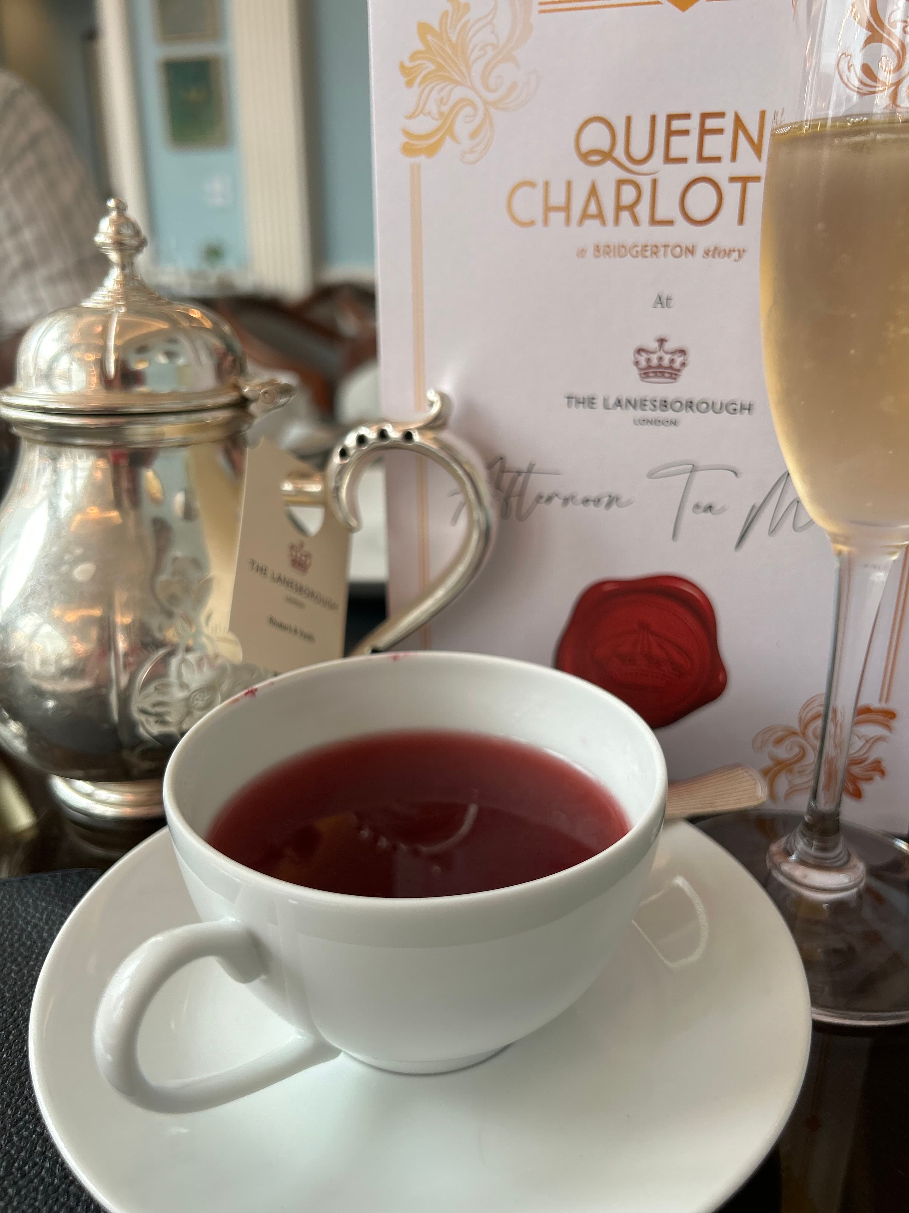 Cup of tea and saucer and a glass of Prosecco