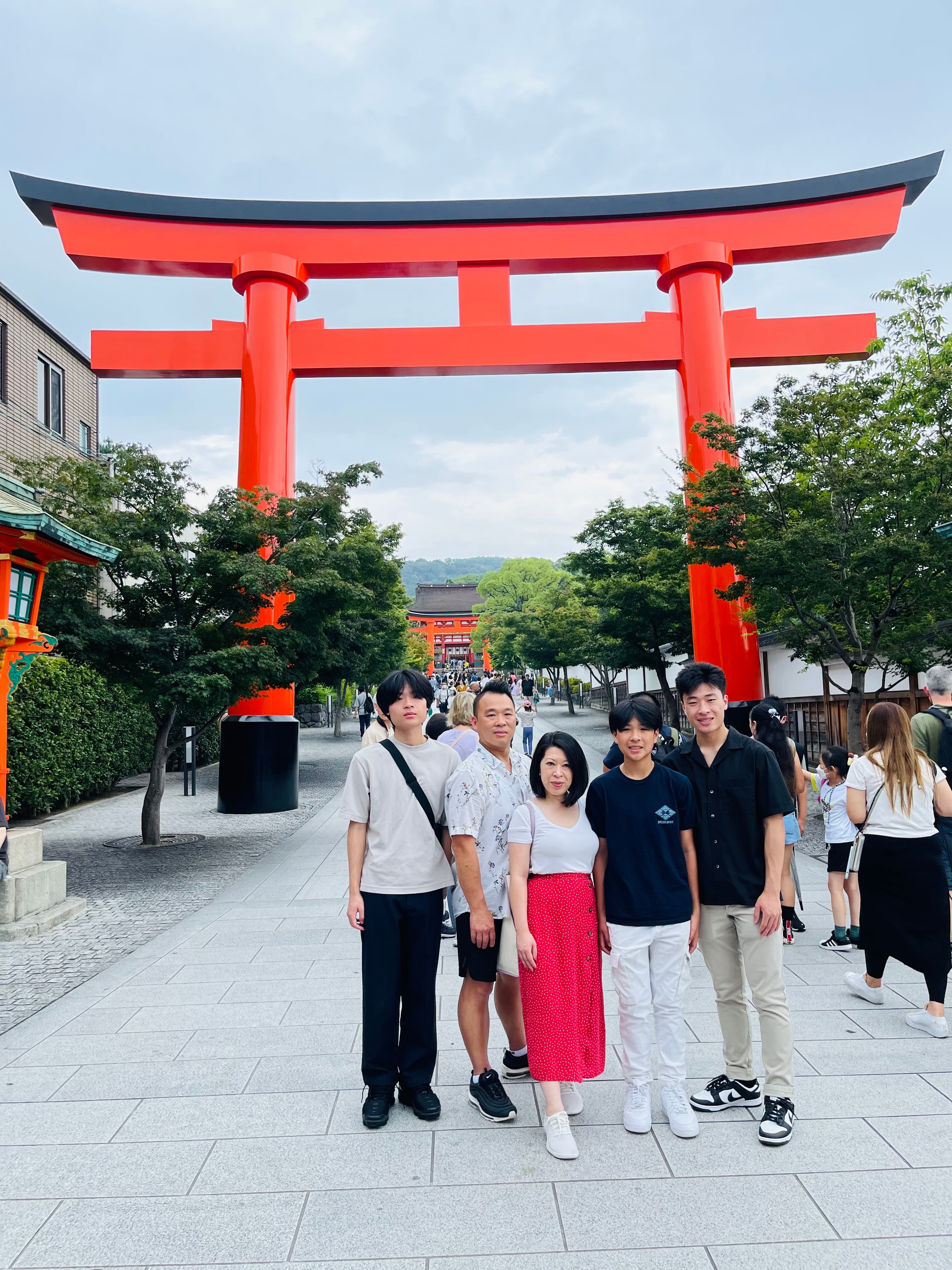 Advisor and family posing in front of a shrine in Japan on a cloudy day