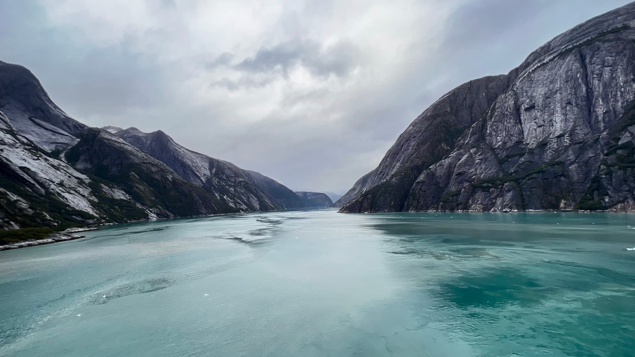 A turquoise lake surrounded by dark, rugged mountains.