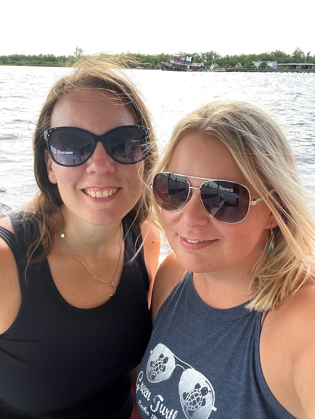 Two women posing for a selfie while wearing sunglasses.