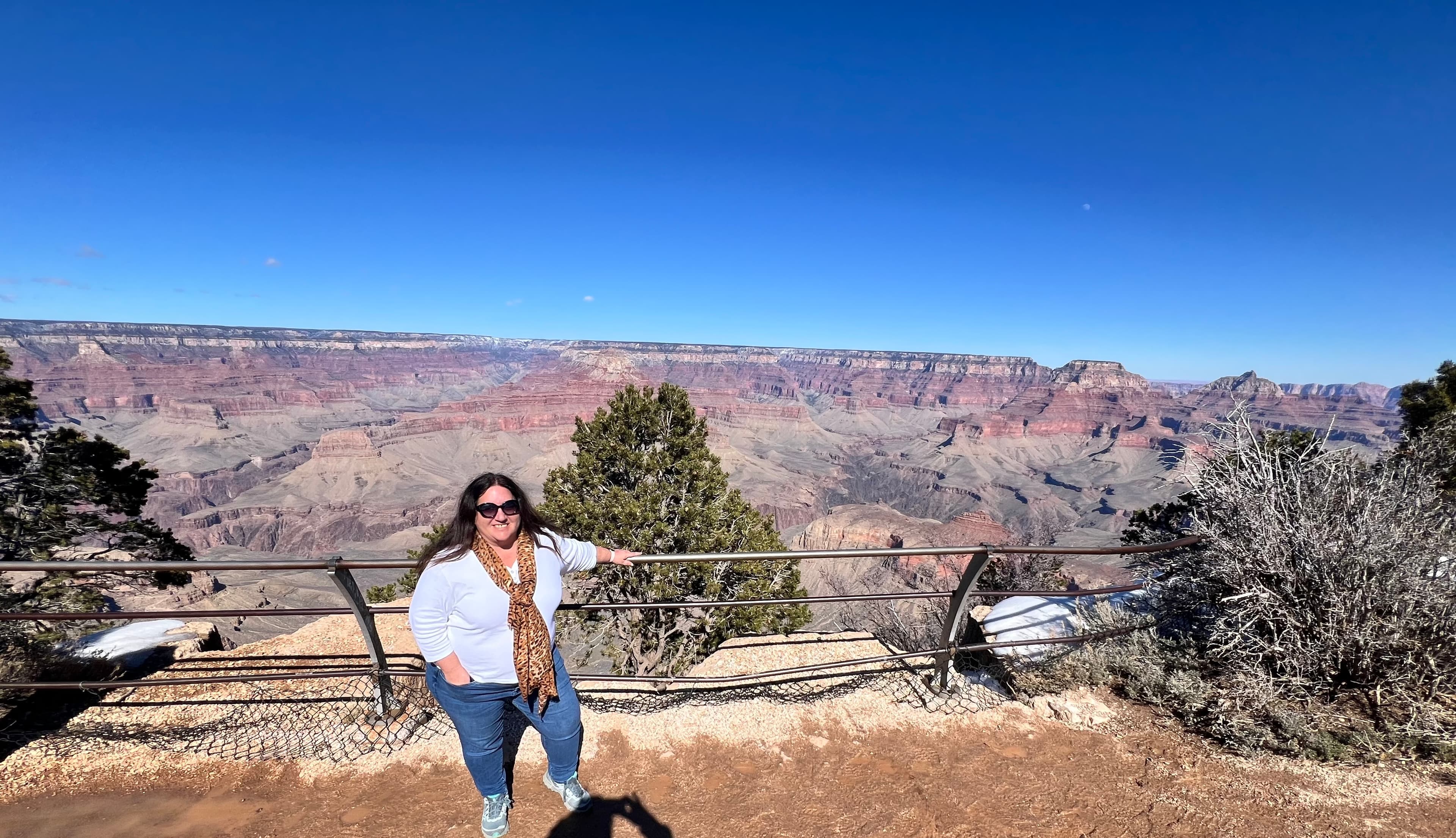 Advisor sitting next to the railing on the edge of the Grand Canyon.