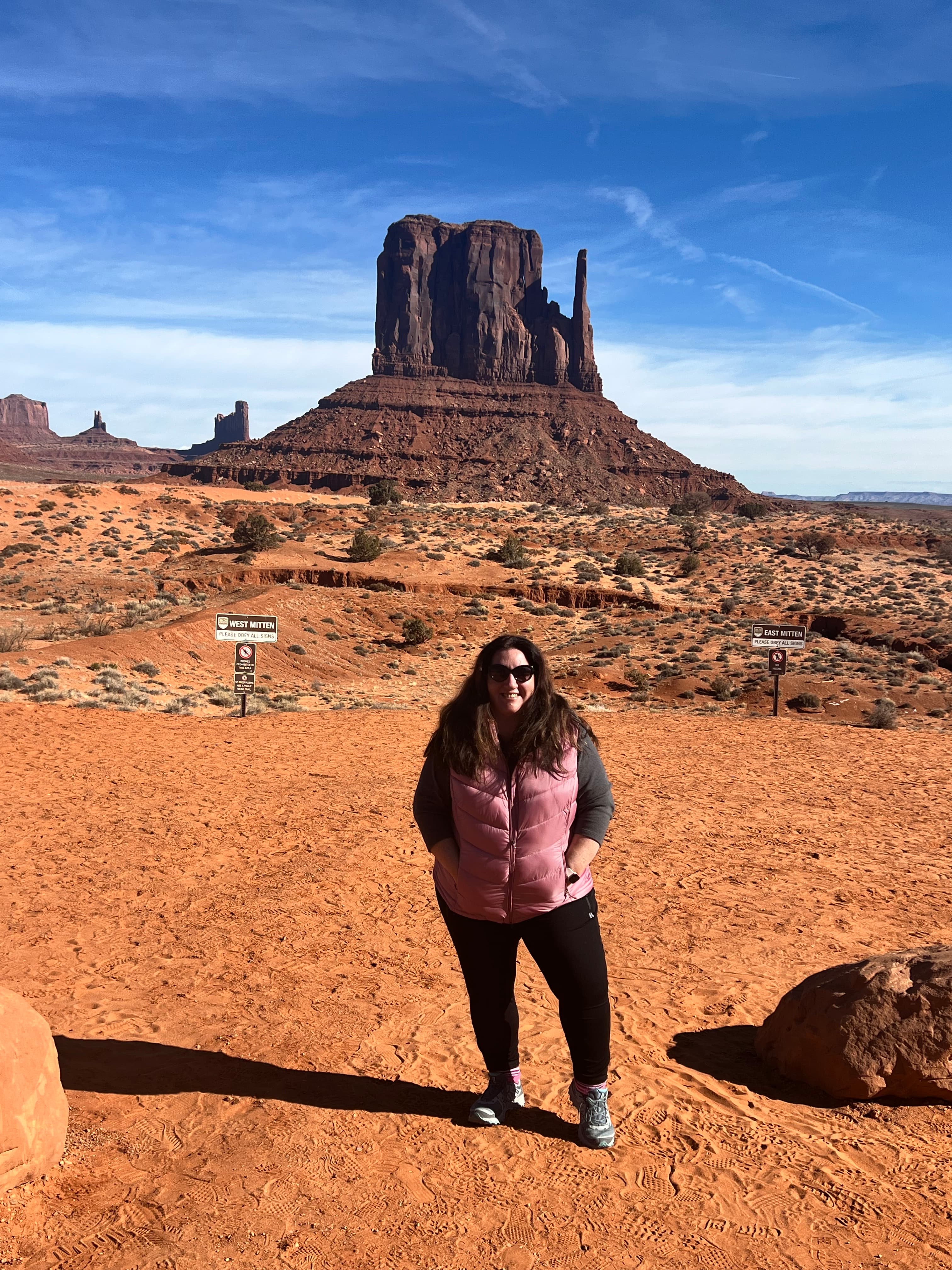 Advisor is standing in the desert in front of a southwestern rock formation.