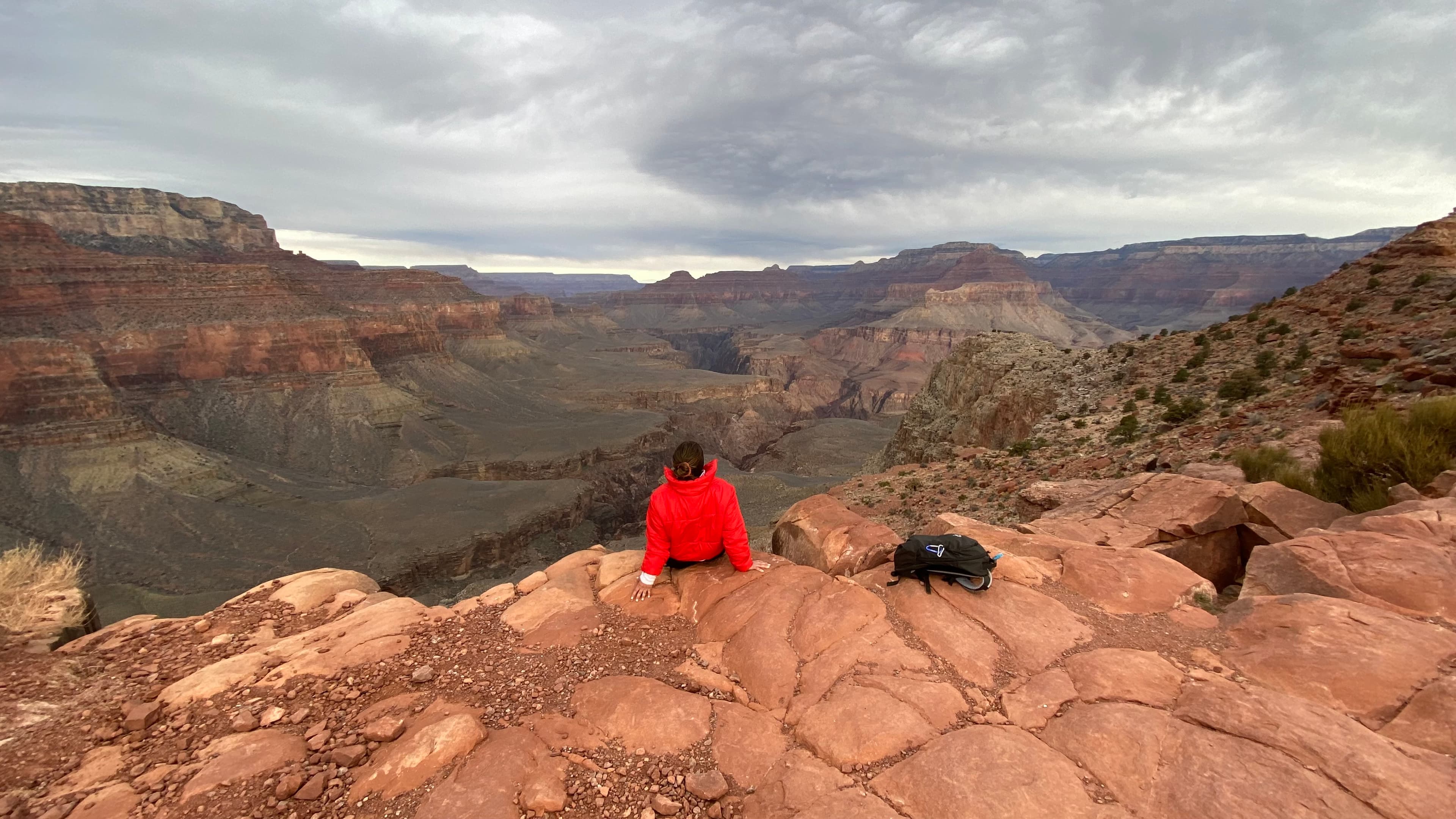 Advisor posing on rock formation on a cloudy day.