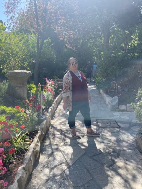 Jenni posing along a cobblestone path outdoors.