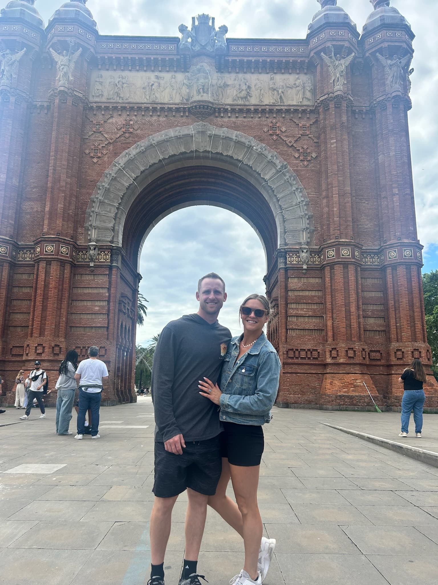 Advisor posing in front of an arched gate on a sunny day.