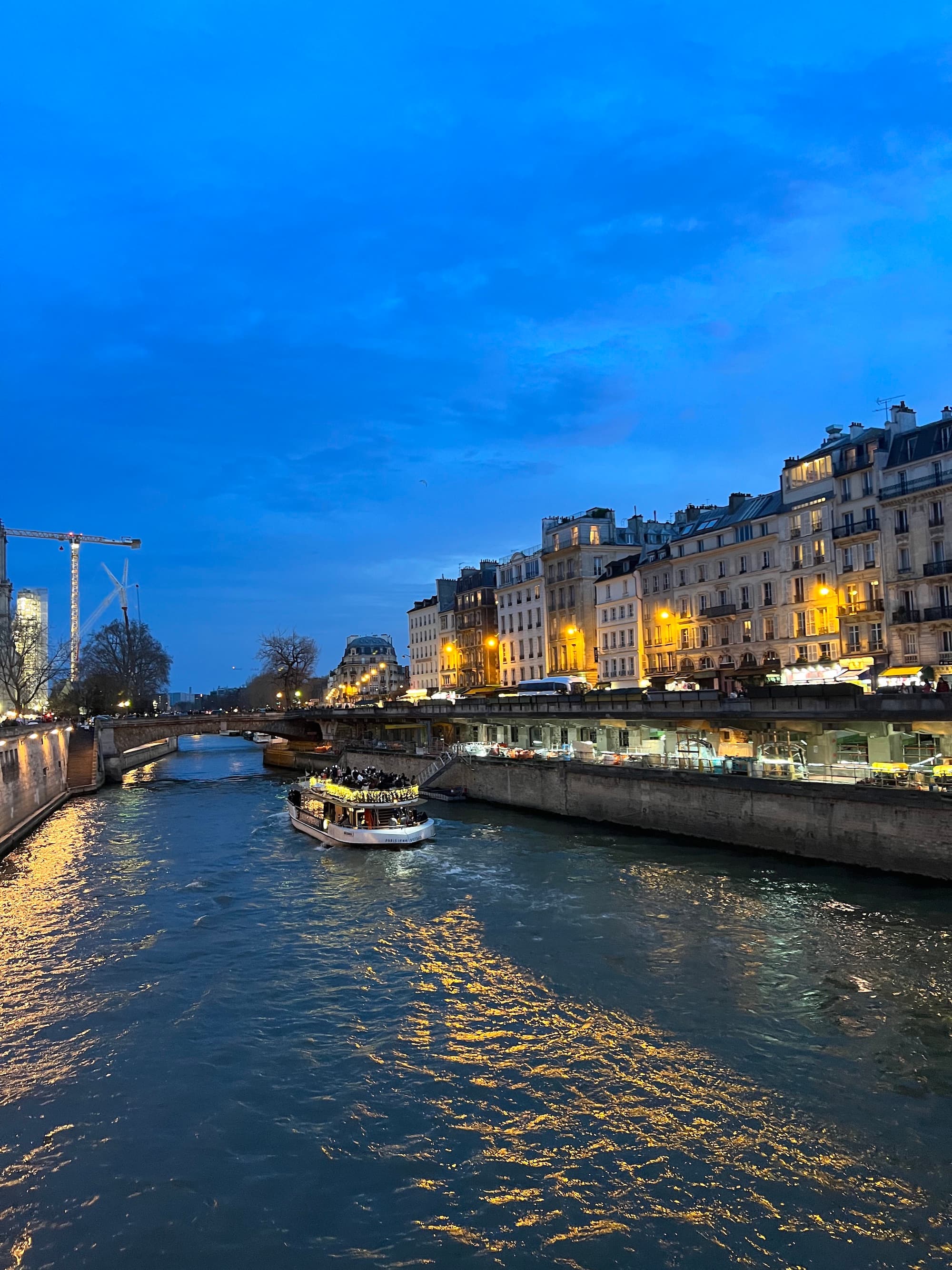 A view of a canal at night with lights along the marina.
