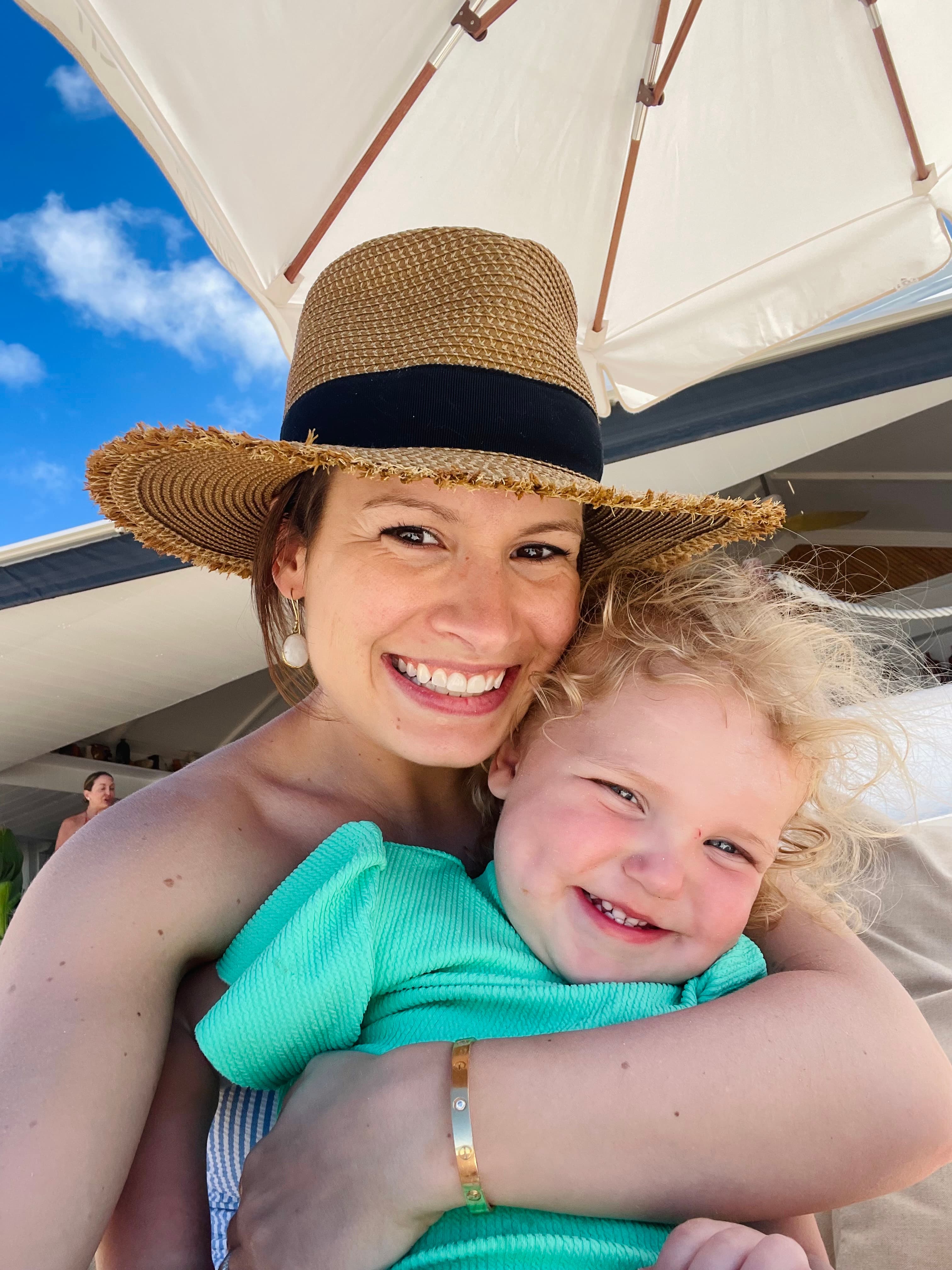Advisor posing for an image with her child on a boat on a sunny day.