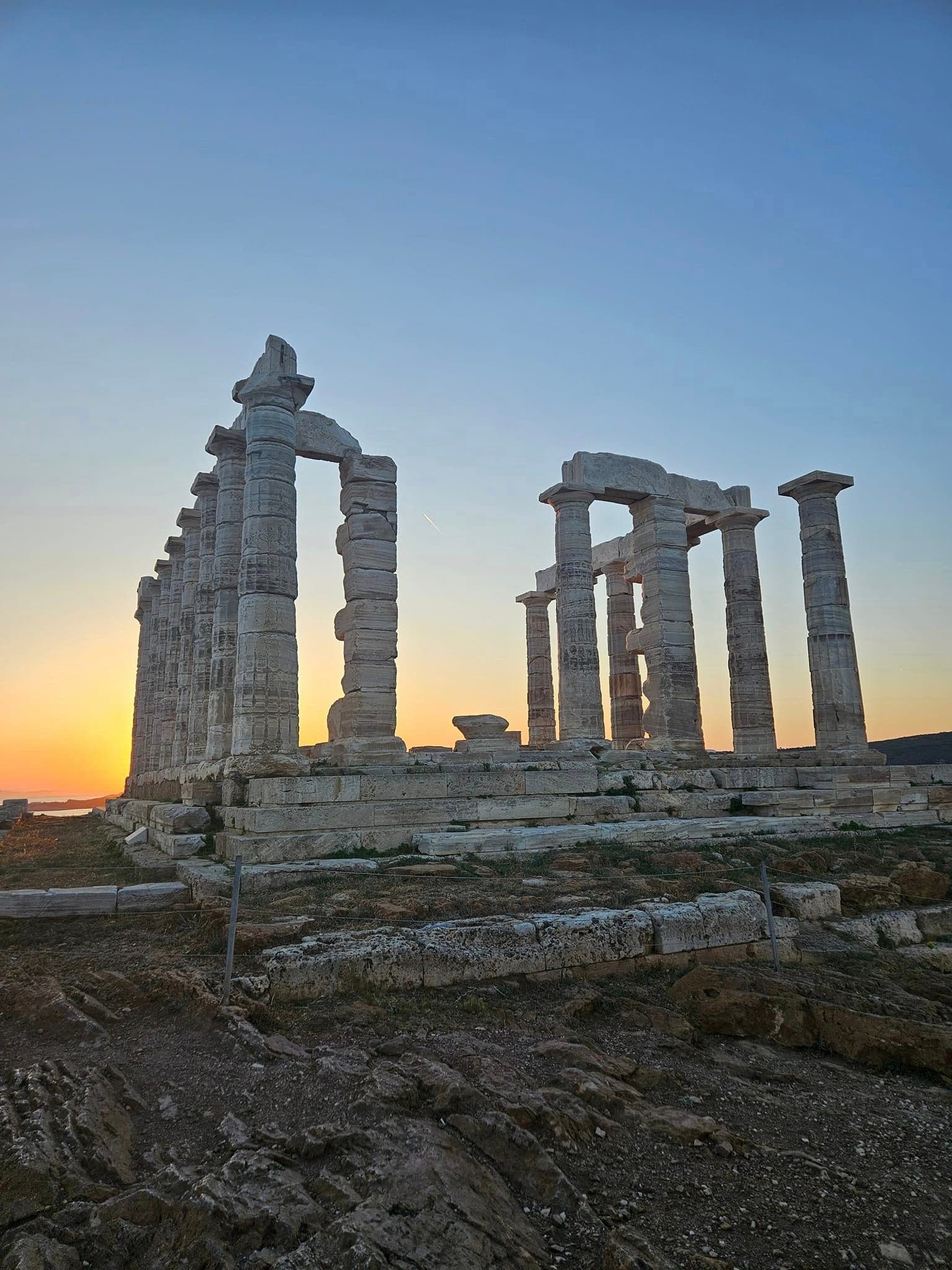 Ruins stand tall against a blue sky at dusk.