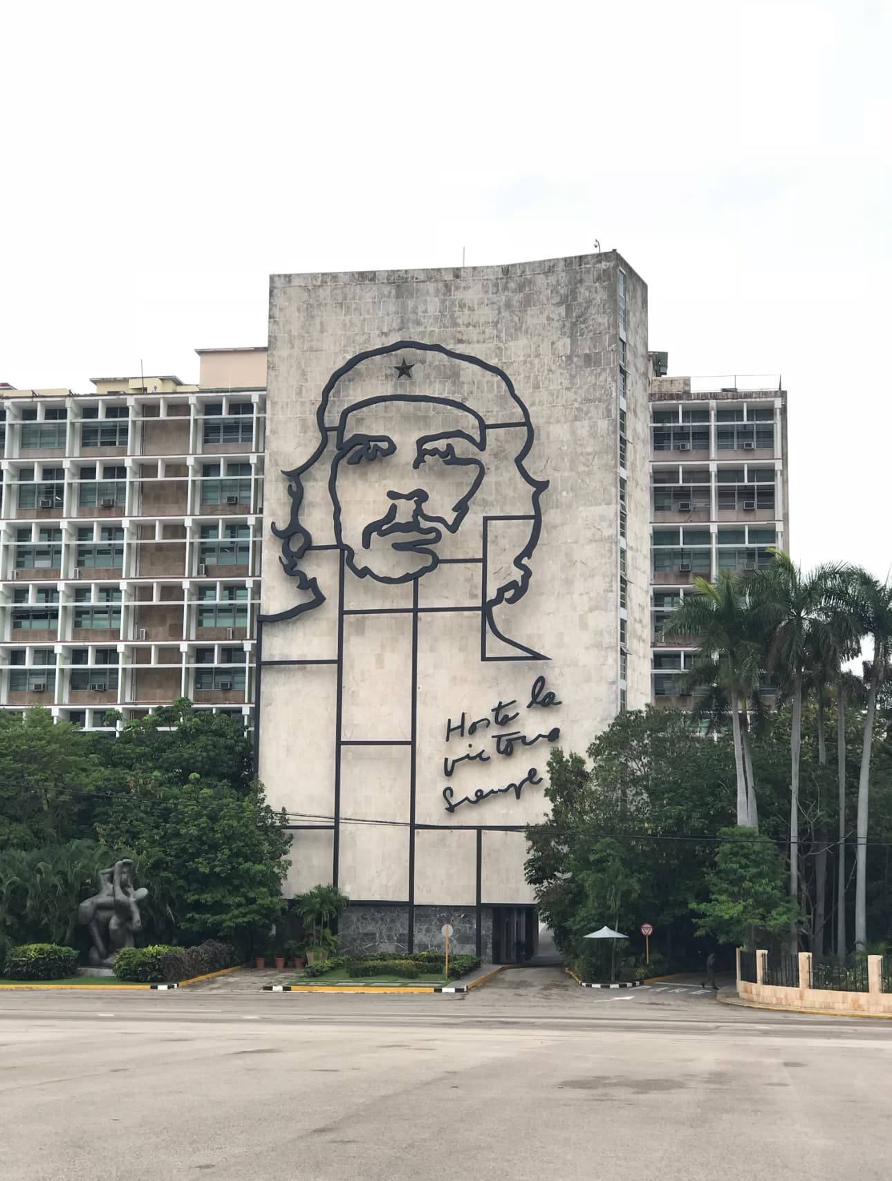 Graffiti mural on the side of a concrete building on a cloudy day.