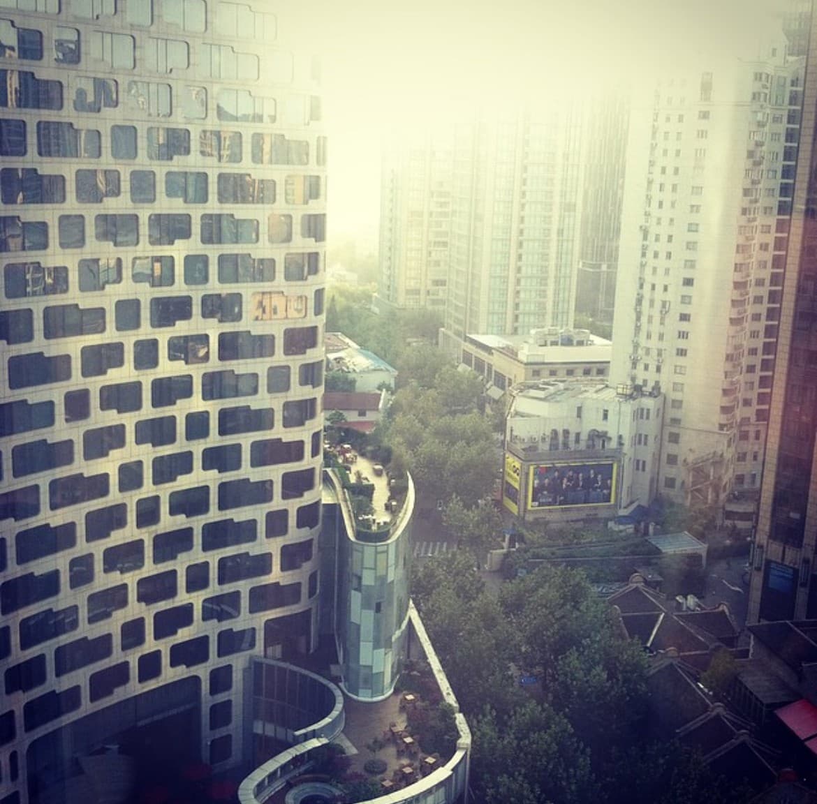 A view of a building and a city in the distance on a sunny day.