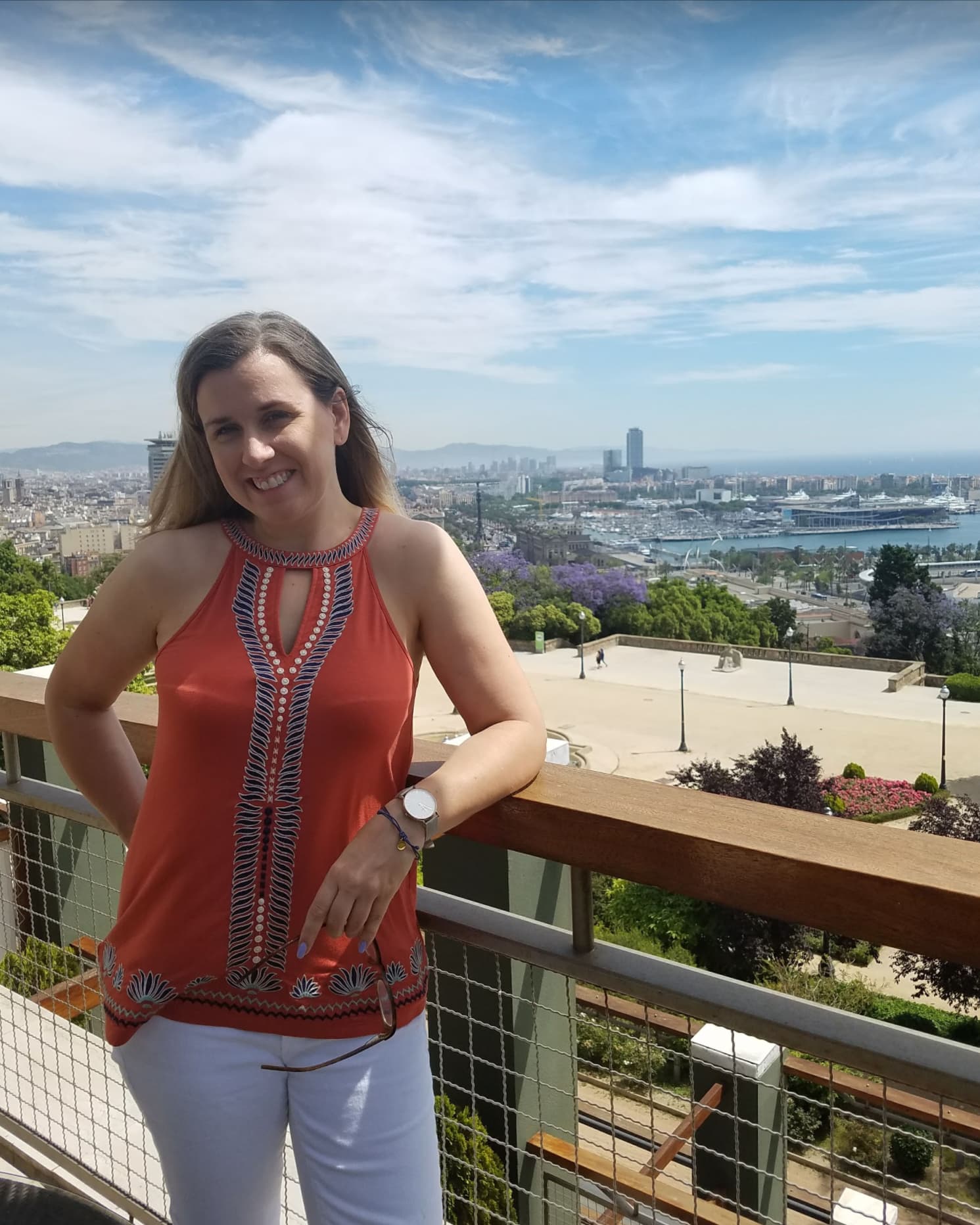 Advisor posing for an image with a city in the distance on a sunny day.
