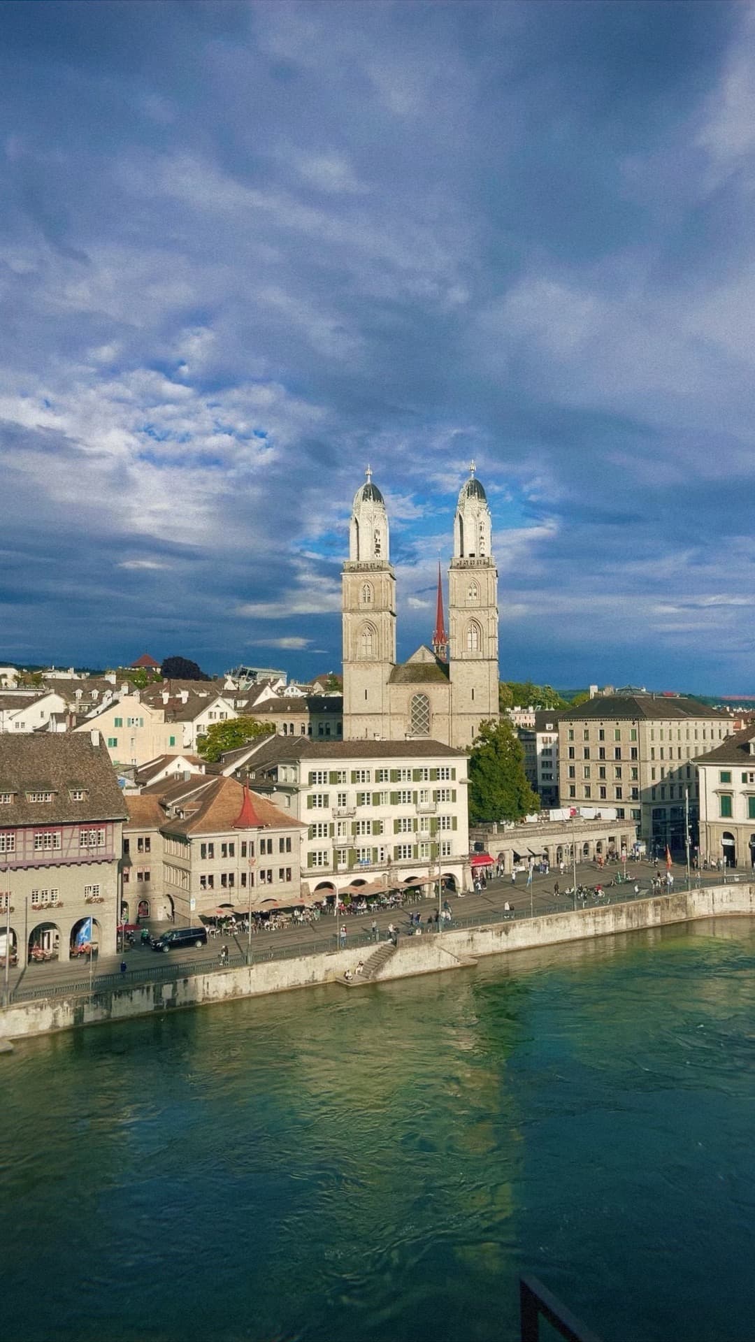 Aerial view of cathedral with two towers as seen from across a river