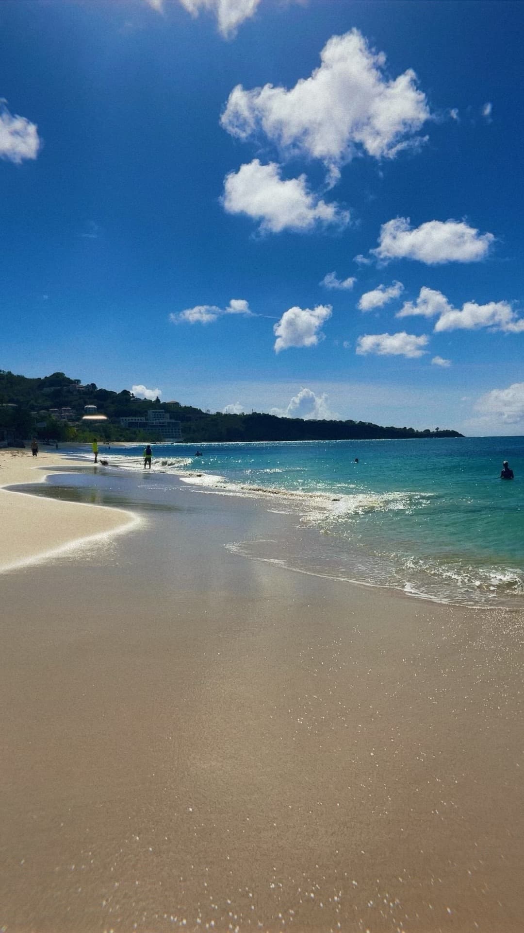 View of a clean beach with calm waves on a sunny day