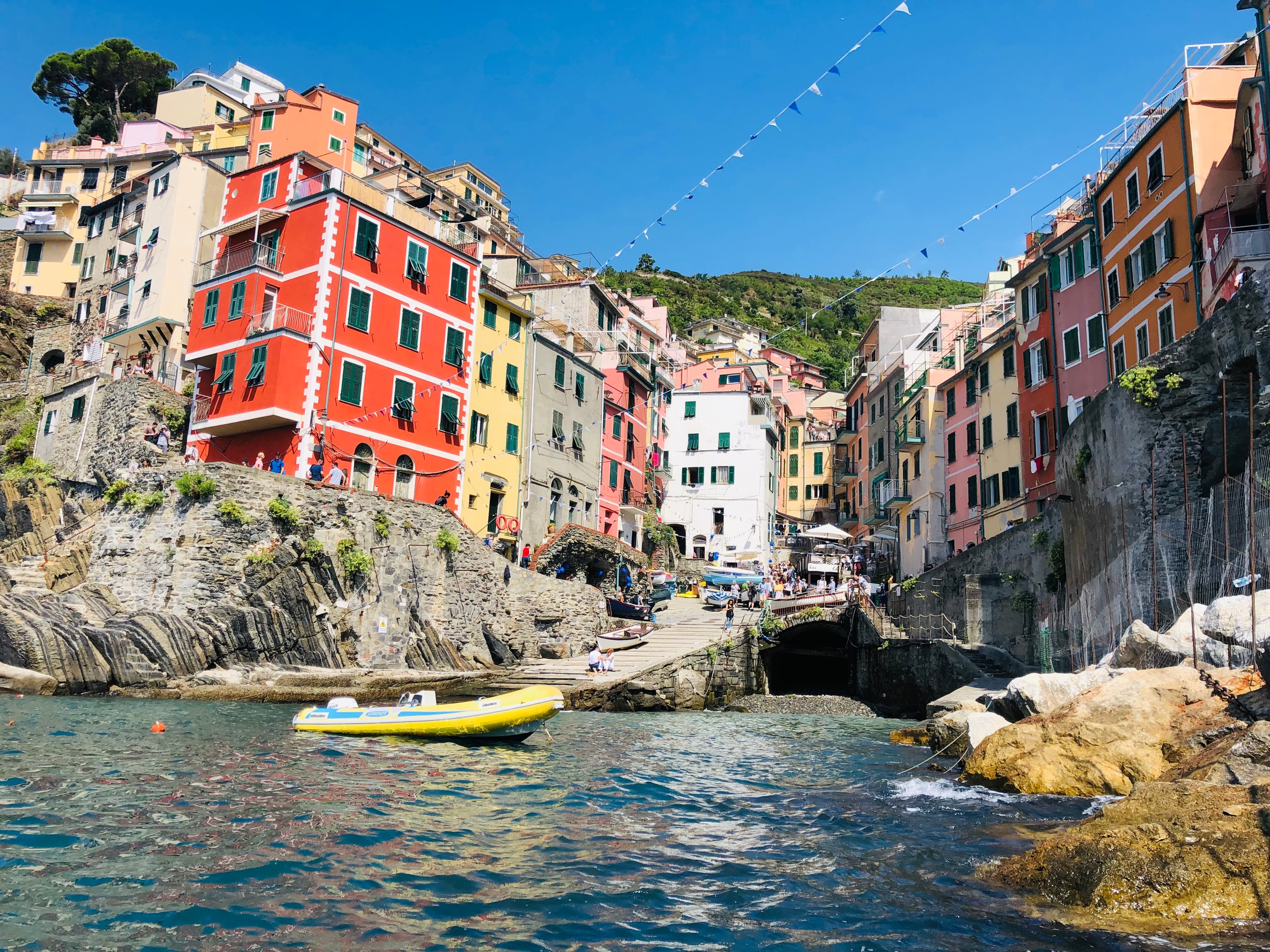 An oceanside town with mountains in the distance on a sunny day.