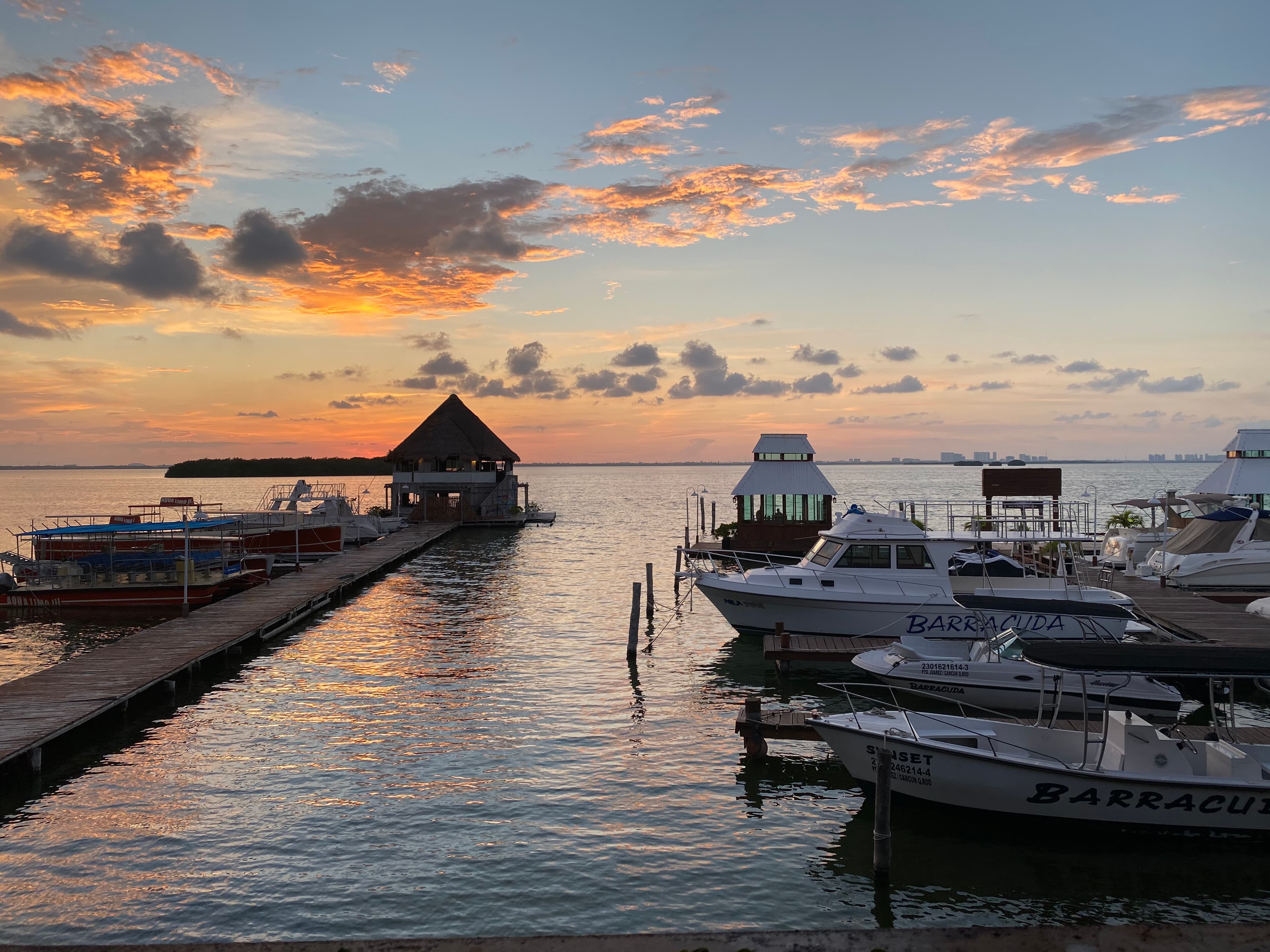 Pretty sunset over a small marina and a long wooden dock