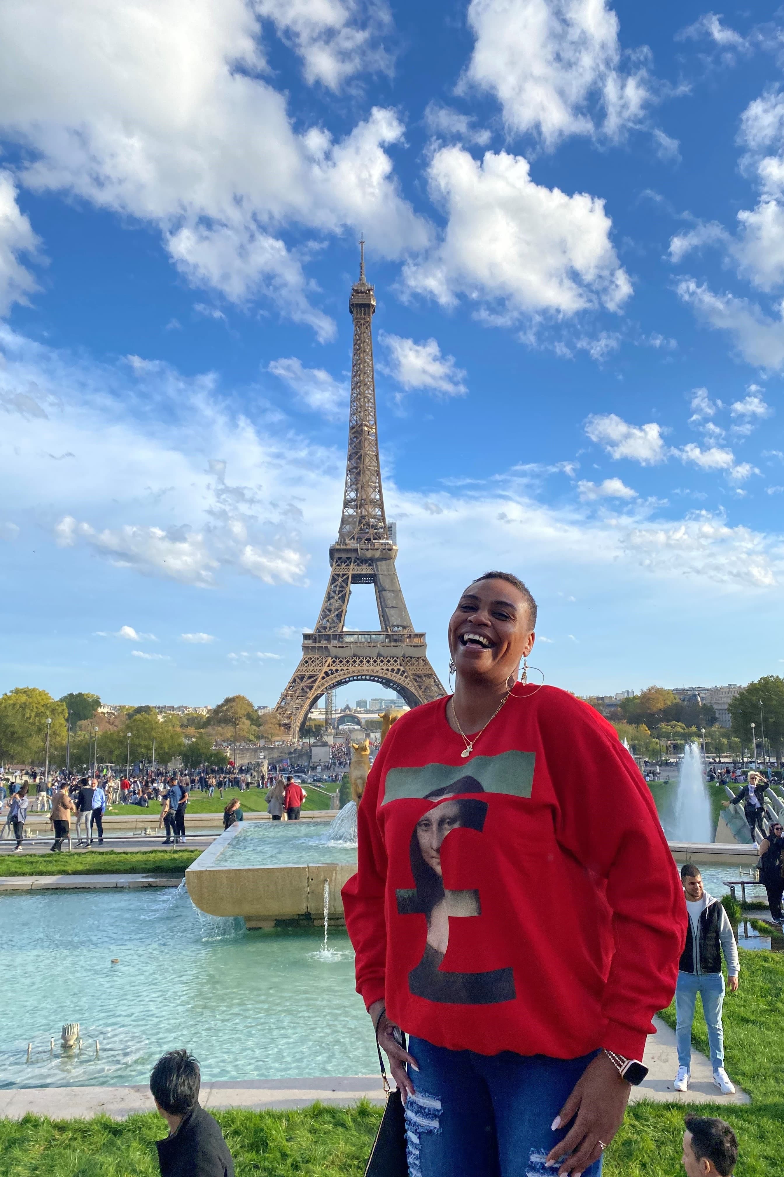 Advisor in a red sweater smiling with the Eiffel Tower in the background