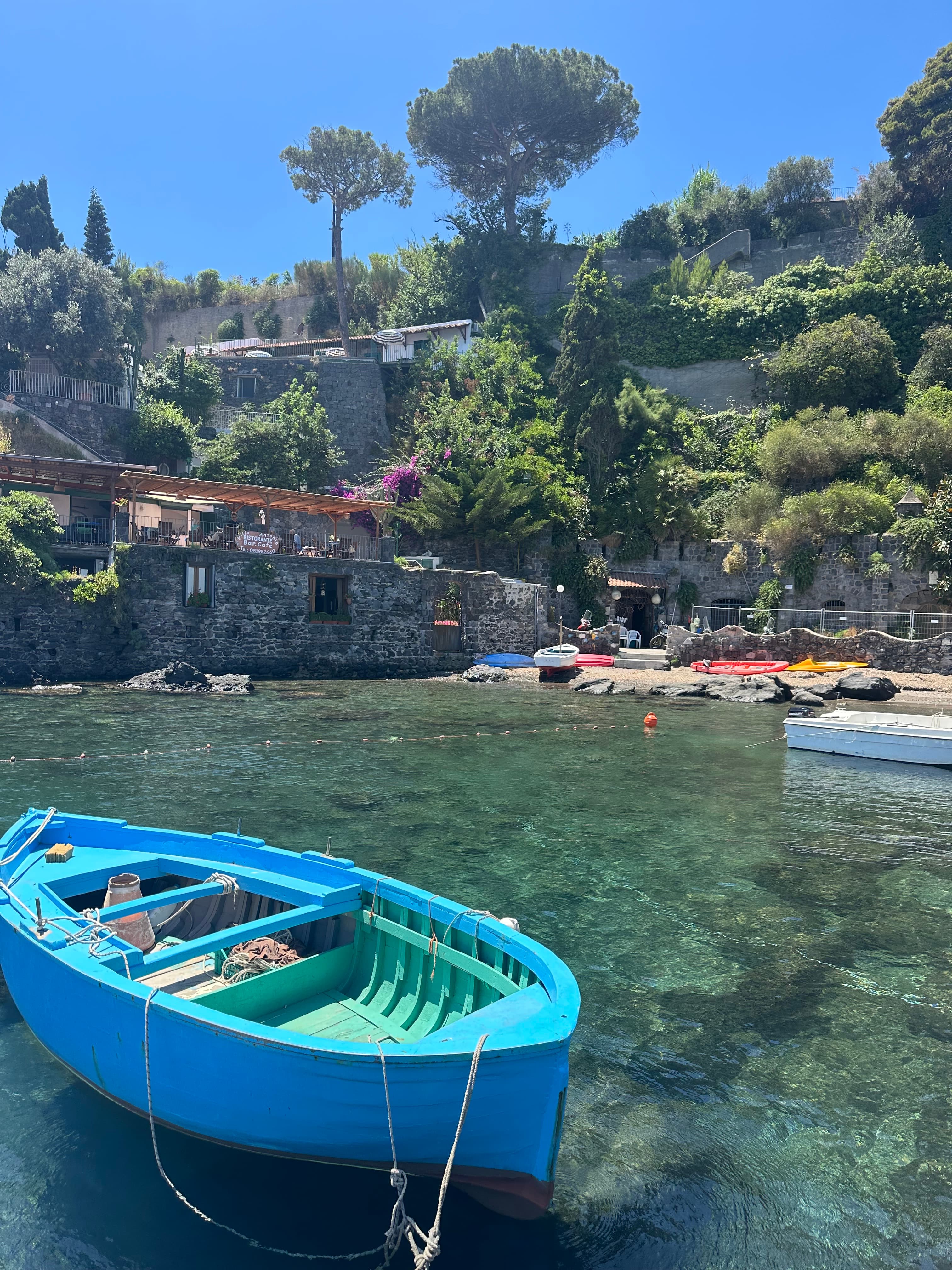 A body of water with boats and a beach in the distance.