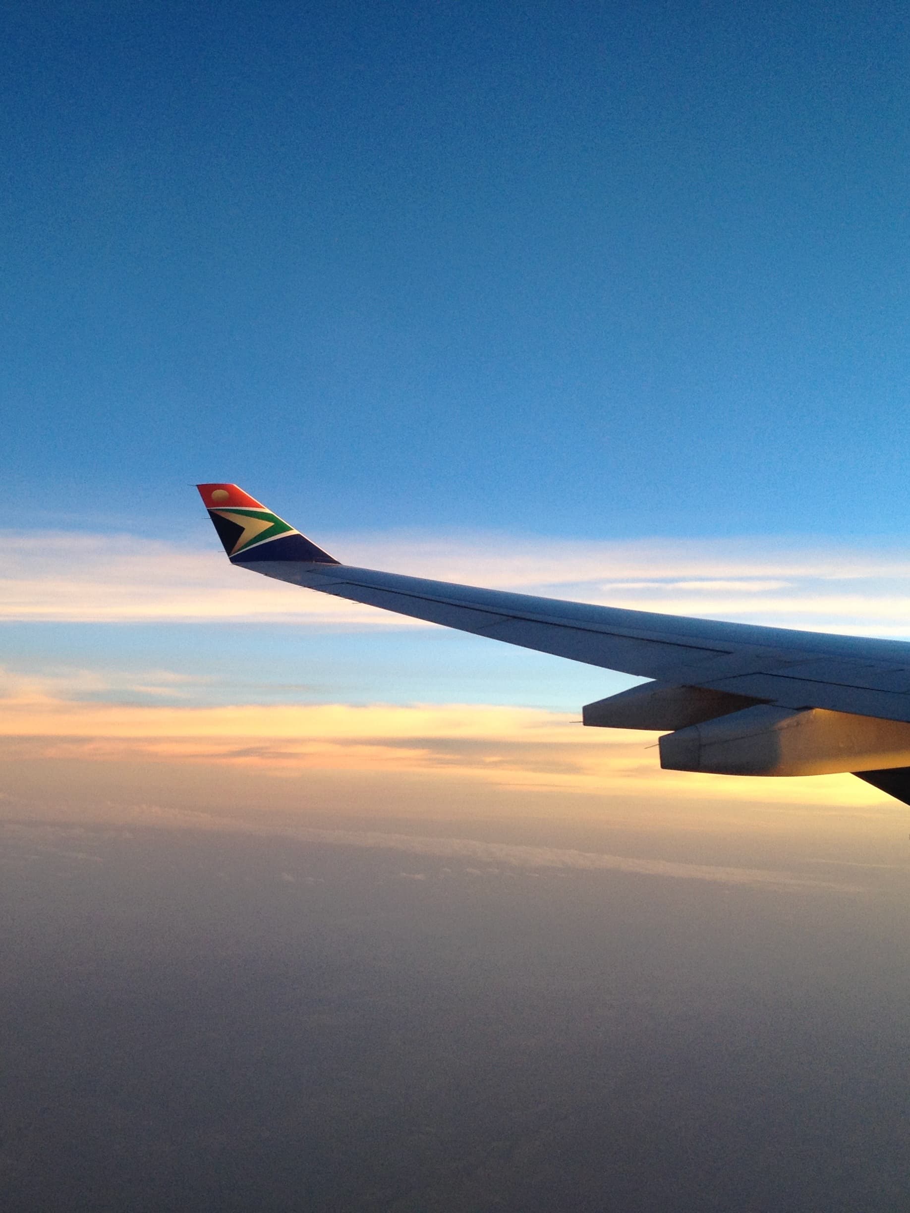 A view of an airplane in flight at dusk.