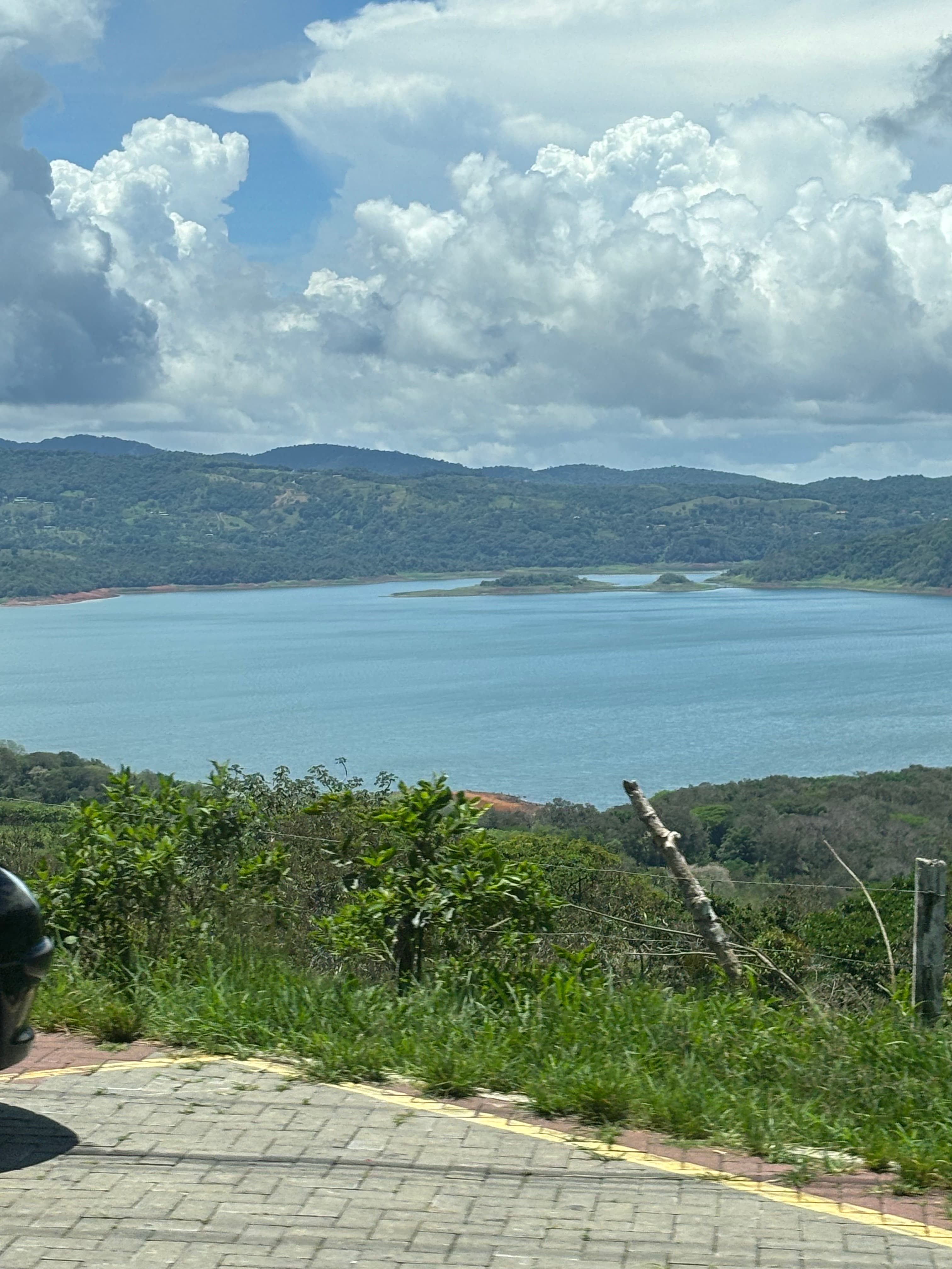 View of a bay surrounded by mountains and greenery on a sunny day