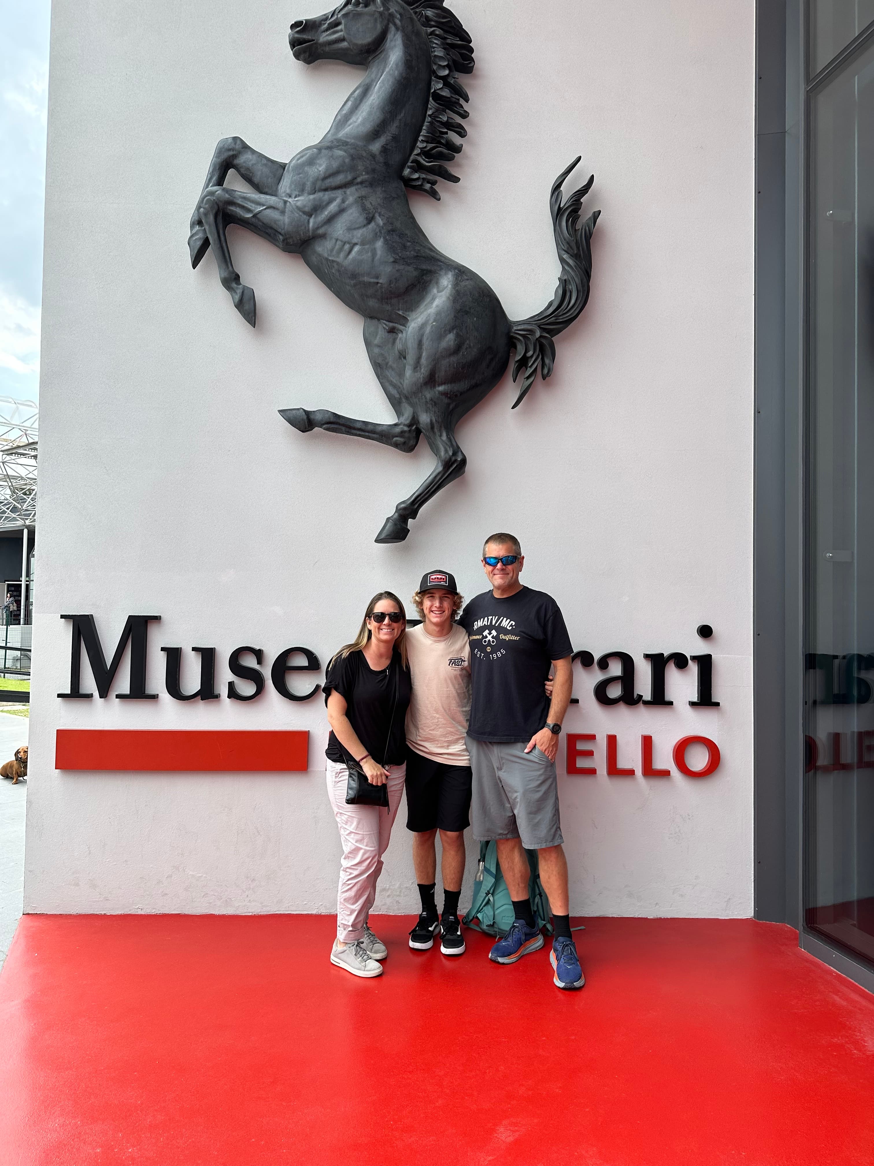 A family posing on the outside of the Ferrari Museum in Monza, Italy.