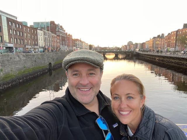 Advisor and partner taking a selfie at sunset with a city canal in the background