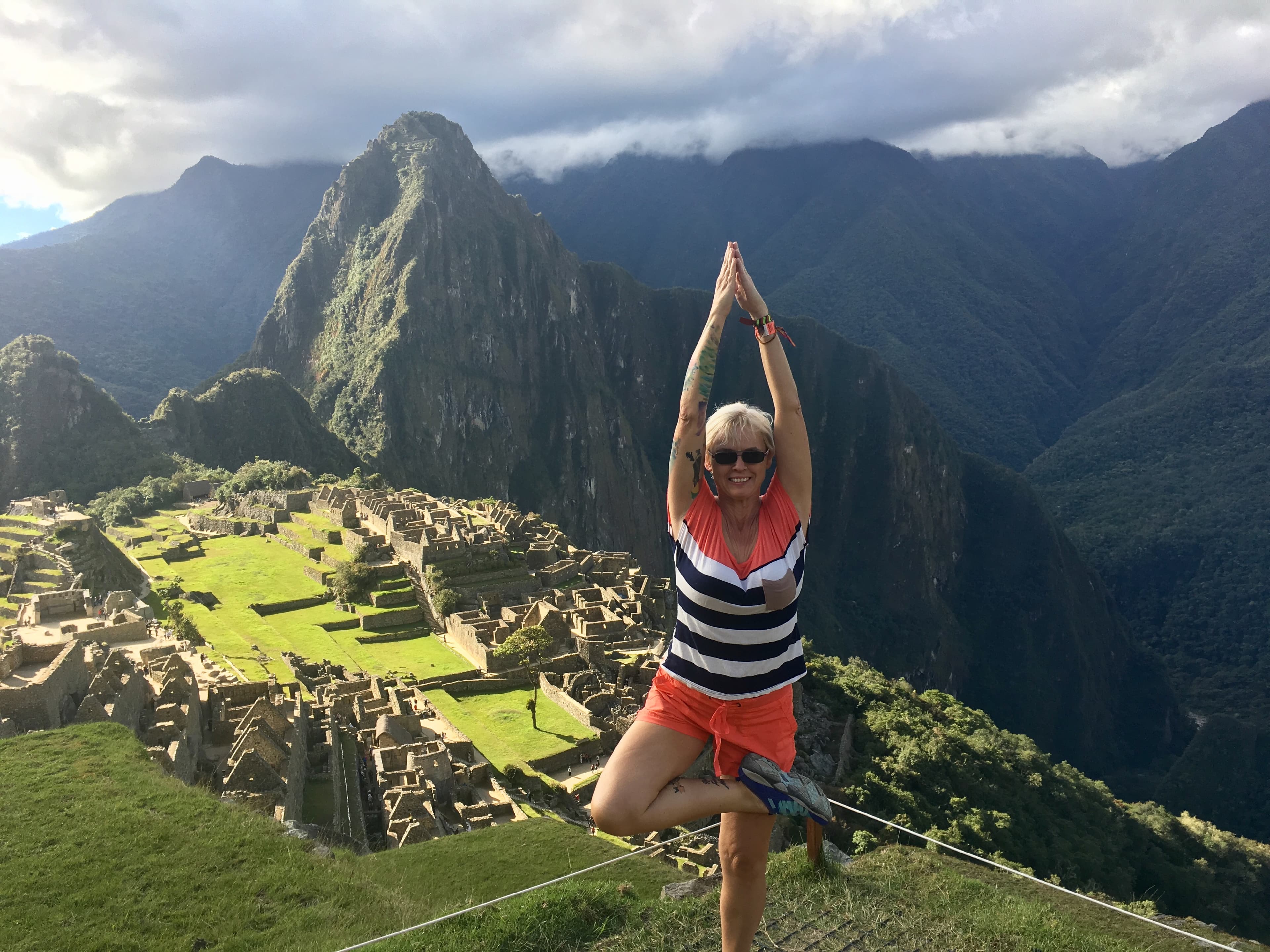 Advisor doing the tree pose with the Machu Picchu ruins behind her
