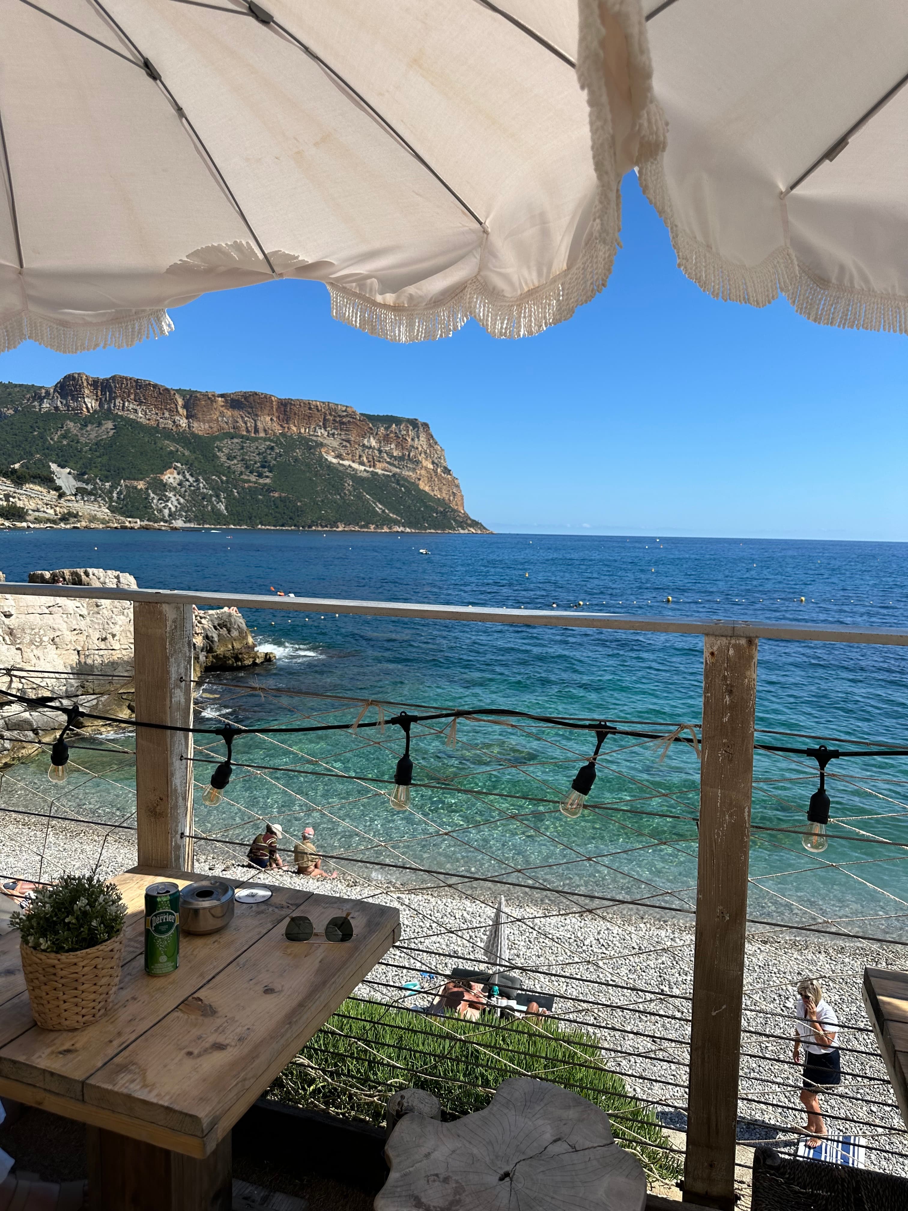 Tables on an outdoor deck next to the beach during the daytime