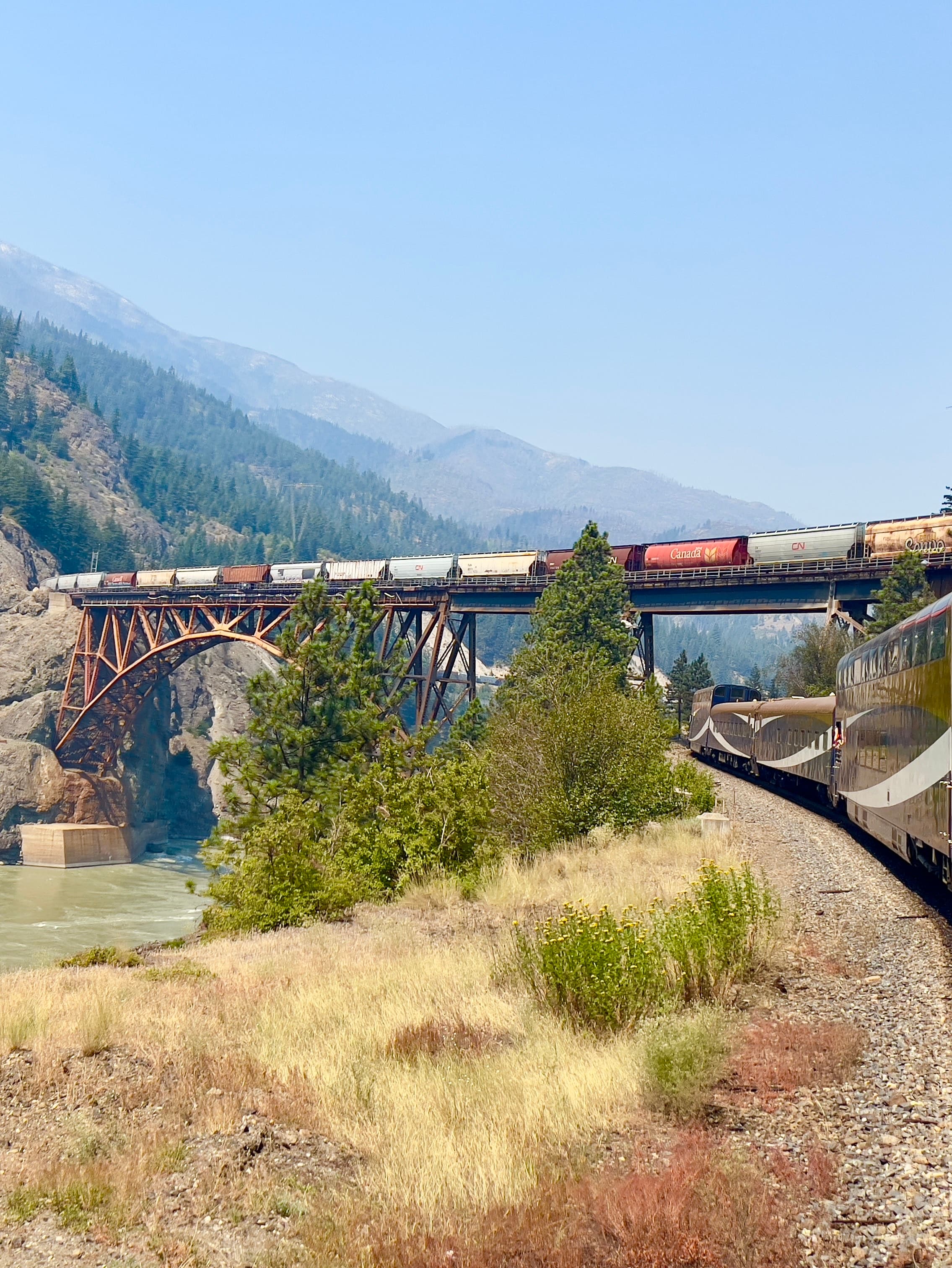View of a train on a bridge in the mountains under clear skies