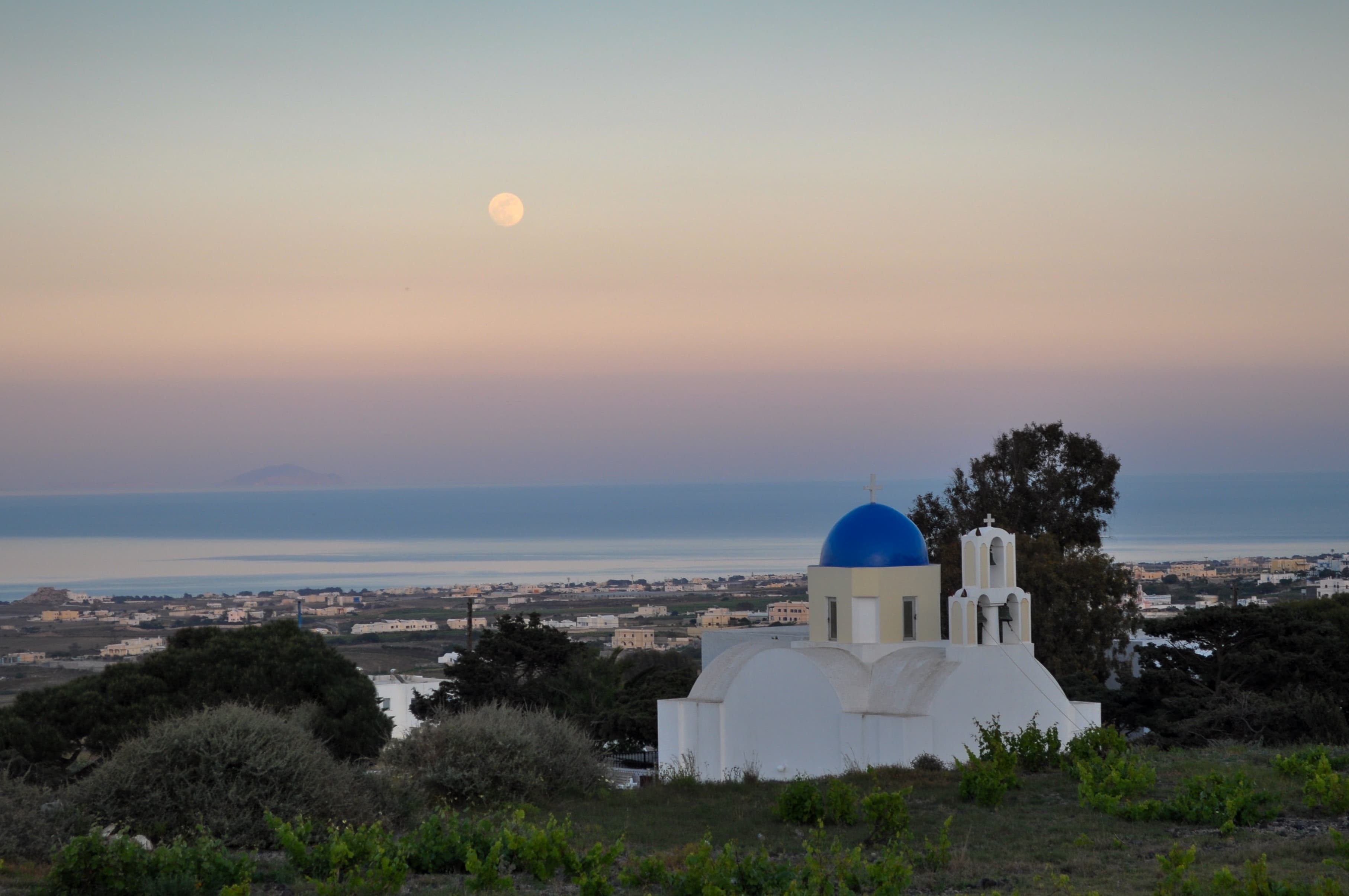 A picturesque church featuring a striking blue dome against a clear sky, showcasing its architectural beauty.