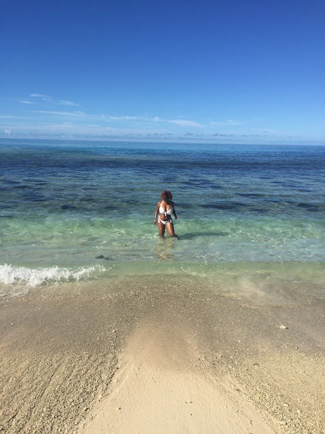 Advisor posing in shallow ocean water on a sunny day at the beach
