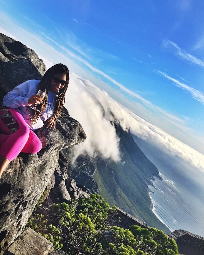 Advisor on a hike high above the clouds with the coastline visible in the distance